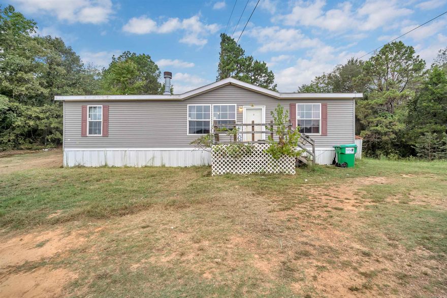 Nestled in a rural setting, this little country charmer 3/2 mobile home sits on 2.65 acres of partially wooded land, offering a perfect blend of comfort and nature. The home features all electric utilities. Spacious kitchen with plenty of cabinets and kitchen island for extra seating. All kitchen appliances convey. Easy maintenance with vinyl flooring throughout. An outbuilding is also included, providing extra storage or workspace.