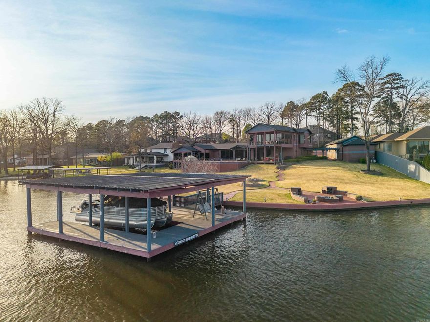 Stunning home on 257' of prime Lake Hamilton frontage with seawall and two covered boat docks. This 6700 square foot estate offers 5 bedrooms, 6.5 bathrooms, and exceptional indoor-outdoor living. Enjoy the saltwater pool, expansive entertaining spaces, home theatre, wine cellar, and breathtaking views from nearly every room! Thoughtfully designed with luxury finishes, multiple living areas, and beautifully landscaped grounds-perfect for entertaining or lakeside relaxing.