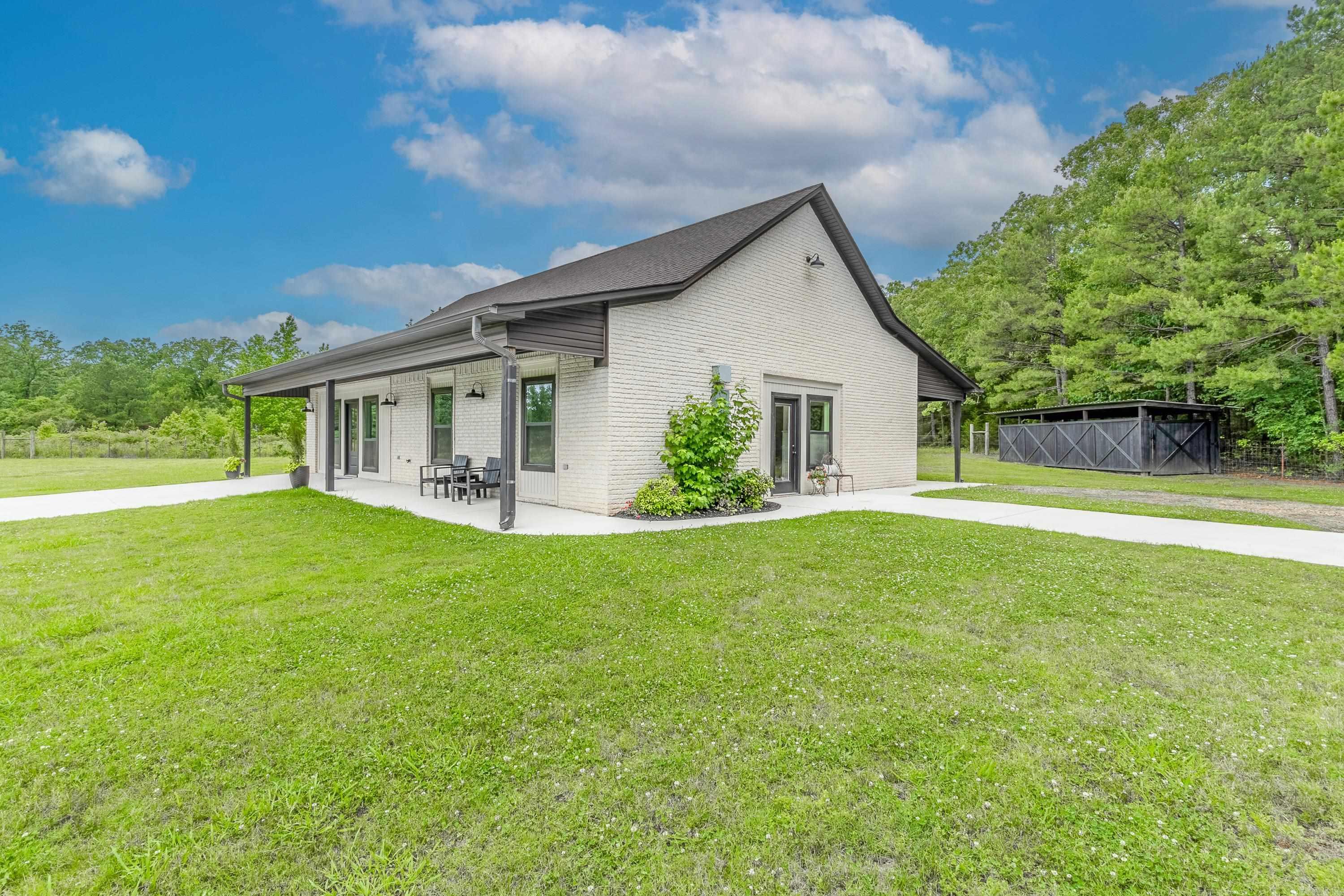Country retreat just outside Conway city limits on Round Mountain Rd. Beautiful complete remodel of 4 bed, 2 bath, brick home. Everything is new! Large open concept kitchen-living space with white quartz countertops, and top-of-the-line stainless steel appliances. Built with energy efficient features including a Solarbord/Techshield roof and Low-E argon windows. New roof, new hot water heater, HVAC system and waterproof LVP floor throughout. Excellent filtered well water. Situated on 1 acre with additional 3 acres available. Storage shed with metal roof and concrete floor. Private, safe, with scenic views.
