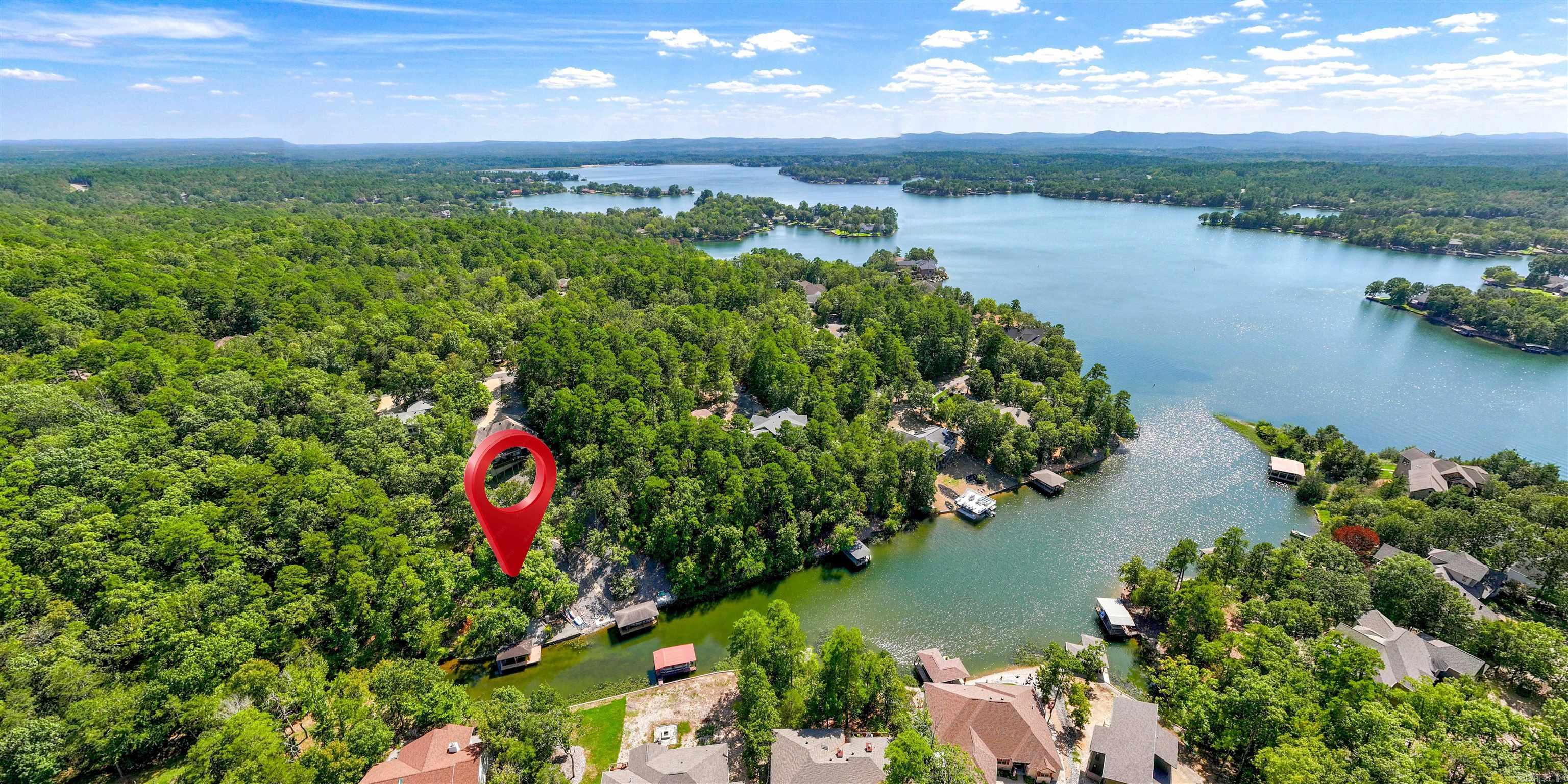 Lake Balboa WATERFRONT on a 3/4+ acre lot with a $40k Boat Dock! This 4 Bedroom 2 1/2 Bath home boasts a Huge Arkansas Room overlooking Treed Privacy and your own Boat Dock with Lift! A Main Floor Primary Bedroom with Walk-in Closet and Ensuite offers access to a Deck with a View! A HUGE Dining Room is large enough for the ultimate Thanksgiving or Christmas Dinner! The Bright Kitchen with Rich Wood Cabinetry and Eating Bar includes a Smooth Top Range, and Eating Area with a View! The Lower Level includes 3 more Bedrooms, one with a walk-out to the Entertainment-sized Deck! A Large Laundry Room leads to the Heated/Cooled Shop with Workbench and Garage Door to the side of the home! Two different paths meander down to the Dock and 944 Acre Lake Balboa! Hot Springs Village boasts 11 Lakes and 9 Golf Courses, the Coronado Fitness Center, Performing Arts Center, 20+ Miles of Walking Trails, Tennis, Pickleball, Mini Golf, Archery Range, 2 Marinas, 2 Beaches, Restaurants, and much more!