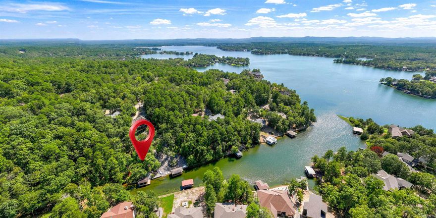 Lake Balboa WATERFRONT on a 3/4+ acre lot with a $40k Boat Dock! This 4 Bedroom 2 1/2 Bath home boasts a Huge Arkansas Room overlooking Treed Privacy and your own Boat Dock with Lift! A Main Floor Primary Bedroom with Walk-in Closet and Ensuite offers access to a Deck with a View! A HUGE Dining Room is large enough for the ultimate Thanksgiving or Christmas Dinner! The Bright Kitchen with Rich Wood Cabinetry and Eating Bar includes a Smooth Top Range, and Eating Area with a View! The Lower Level includes 3 more Bedrooms, one with a walk-out to the Entertainment-sized Deck! A Large Laundry Room leads to the Heated/Cooled Shop with Workbench and Garage Door to the side of the home! Two different paths meander down to the Dock and 944 Acre Lake Balboa! Hot Springs Village boasts 11 Lakes and 9 Golf Courses, the Coronado Fitness Center, Performing Arts Center, 20+ Miles of Walking Trails, Tennis, Pickleball, Mini Golf, Archery Range, 2 Marinas, 2 Beaches, Restaurants, and much more!