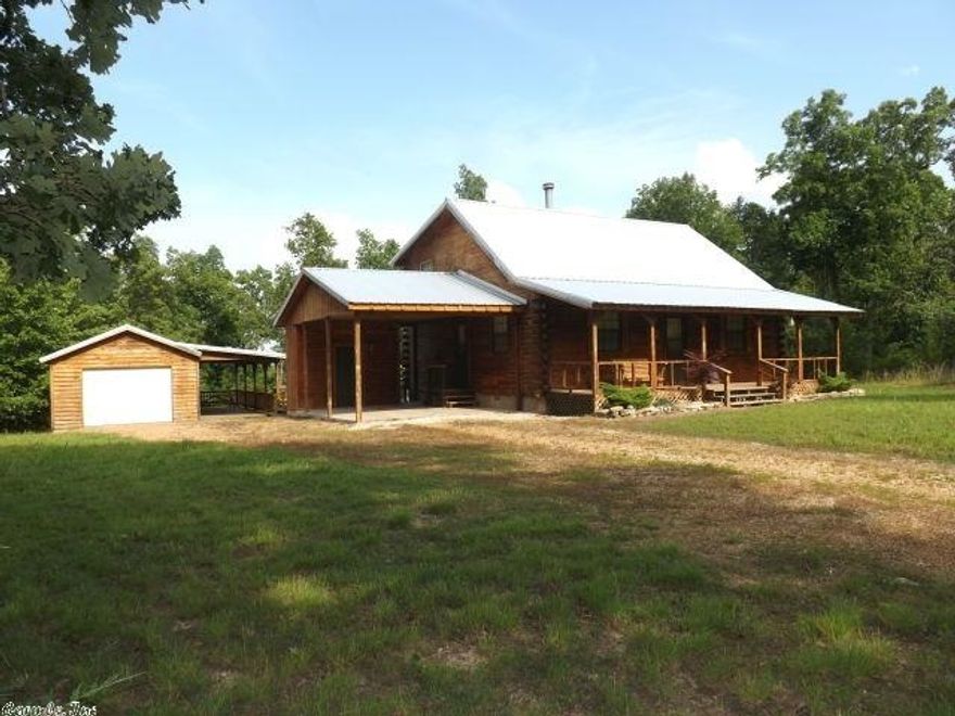 1994-BUILT LOG HOME ON 8 ACRES! 1600 sq feet with  3 bedrooms, 1 3/4 baths, cedar interior walls, open living room/dining with beautiful native stone gas log fireplace, central H&A, rear deck and large covered front porch, metal roof, one car garage with open covered BBQ or work area, in a private setting surrounded by trees. This home would be great for full-time living or a dream vacation get-away. Use of 7 lakes, 2 golf courses, parks, pools, and hiking trails if owner purchases a Cherokee Village lot.