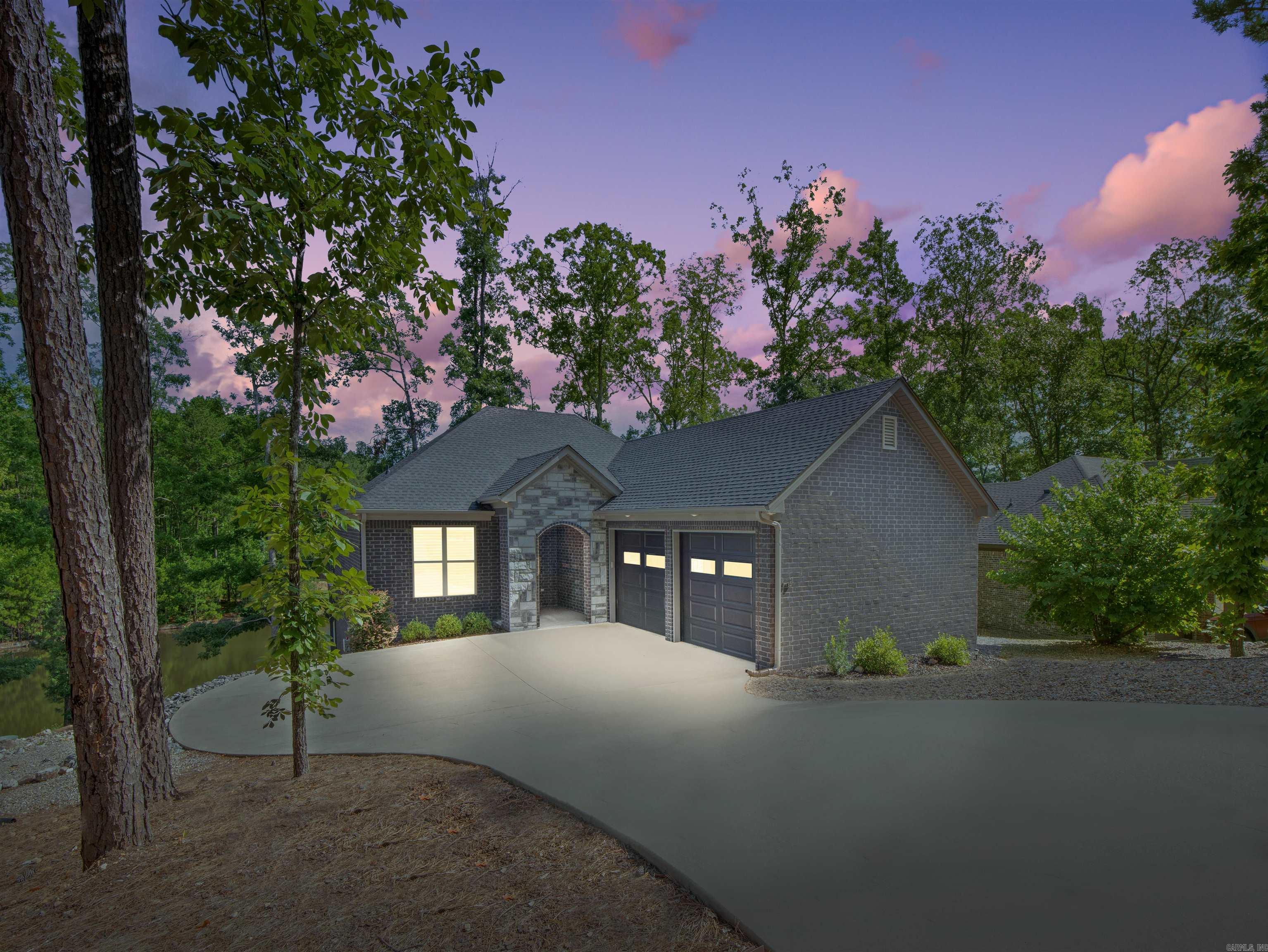 Live your best lake life in this stunning all-brick home on Lake Estrella, nestled inside the coveted gated community of Hot Springs Village. Built in 2021, this low-maintenance gem welcomes you with a charming stone arch entry. Inside, you'll love the open floor plan, luxury vinyl flooring, and a wall of windows that perfectly frame tranquil lake views. The gourmet kitchen features Quartz countertops, a walk-in pantry, and a wine coolerāperfect for entertaining. The spacious primary suite offers a double vanity, oversized walk-in shower, and a custom closet with built-ins. Guests will appreciate their own ensuite bedroom for added privacy. Step outside to your private swim dock or unwind on the back deck while soaking in the peaceful setting. Just minutes from all the Village amenities, this home blends modern comfort with lakeside serenity. Donāt miss the video tour attached to listing! (Agent See Remarks)
