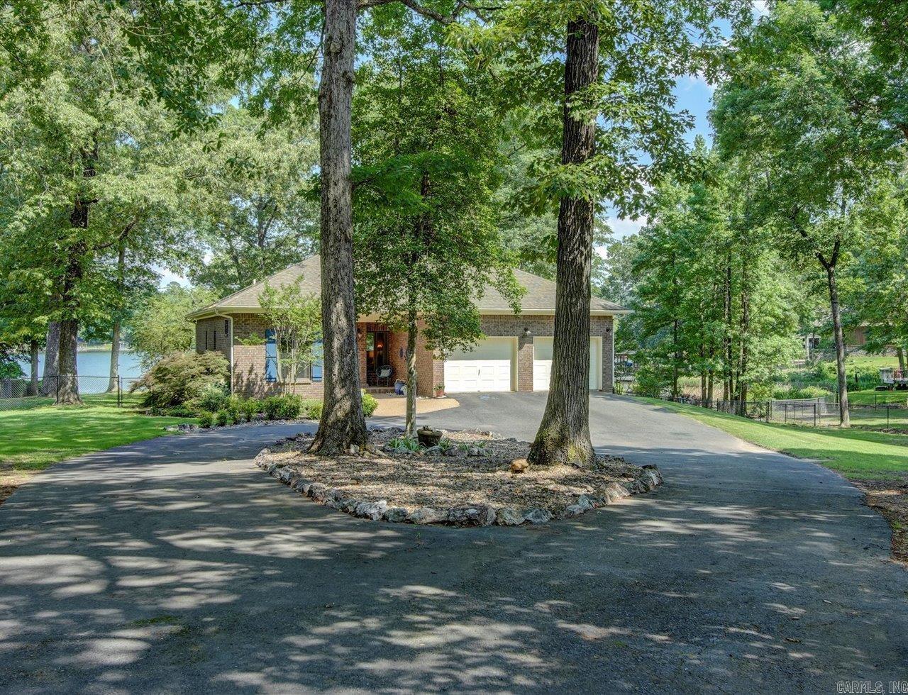 Stunning Lakefront Home on 1.5 Acres with Amazing Views, 236 feet on Lake Catherine! Welcome to your private oasis! This beautiful single story, 3-bedroom, 2-bathroom lakefront home is nestled on 1.5 acres of parklike setting, offering breathtaking views and unparalleled tranquility. Located in the desirable Lakeside school district, this property combines luxury and comfort with a prime location. Step inside to an open floorplan designed for modern living and entertaining. The chef's kitchen is a standout feature, boasting top-of-the-line appliances, granite countertops, and a spacious island that doubles as a breakfast bar. The living area flows seamlessly from the kitchen, with large windows and French doors that frame stunning lake views and flood the space with natural light. The split-bedroom layout ensures privacy, with a luxurious primary suite on one side of the home featuring a walk-in closet and an en-suite bathroom. Two additional bedrooms and a full bath are situated on the opposite side, perfect for family or guests. The expansive property is a nature lover's dream, with manicured lawns, mature trees, and picturesque landscaping.