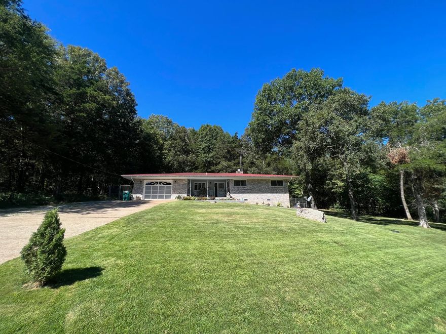 Enjoy your morning coffee while watching the abundance of deer & beautiful Koi fish. Three Bedroom two bath brick home situated on two lots with wonderful shade trees. This property features a large brick fireplace with gas insert, custom teak wood windows from France, spacious sunroom with mini split, fenced back yard with Koi pond, and one car garage with extra storage space. Pride of ownership is evident throughout this property nestled in the Ozarks.