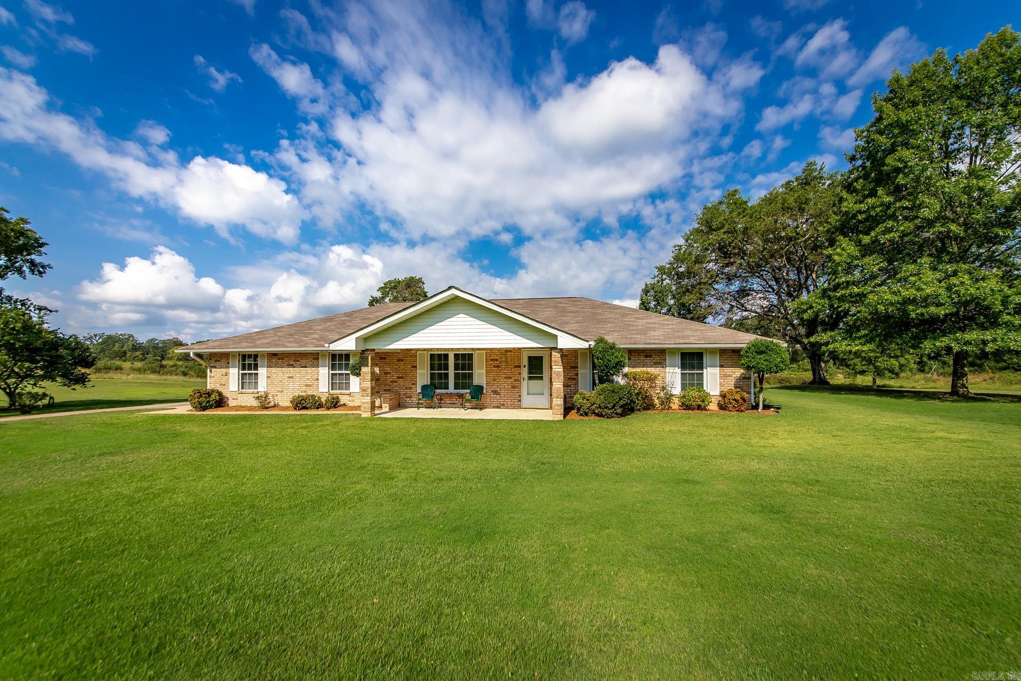 Spread out and enjoy this meticulously maintained, one-level brick home set on approximately 3± level acres. A charming covered front porch welcomes you inside, where the living room features beautiful hardwood floors and a cozy electric pellet stove. The updated eat-in kitchen boasts granite countertops, stainless steel appliances, and a refrigerator that conveys. A spacious laundry room with outdoor and bathroom access adds convenience. Both bedrooms include large walk-in closets, offering comfort and functionality. Step outside to a large covered back patio, perfect for relaxing or entertaining. The property also features a dream shop with electricityāideal for hobbies, storage, or a workshopāas well as a two-car side-load garage with a storm shelter and an additional storage area with built-in shelving. This property blends comfort, practicality, and endless possibilities! Agents, please see remarks.