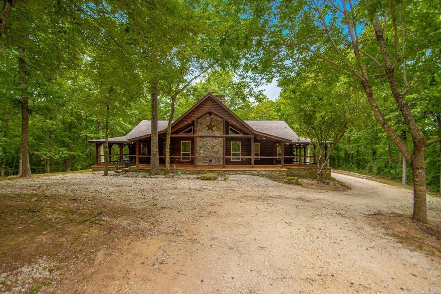 Tucked away on 19.36 peaceful wooded acres, this stunning log cabin retreat offers the perfect blend of privacy, comfort, and year-round enjoyment—all just 15 minutes or less from town. Behind the gated entrance, you’ll find a serene property designed for both relaxation and functionality, surrounded by mature trees and the beauty of every season. The inviting wraparound porch is ideal for morning coffee, quiet evenings, and taking in the sights and sounds of nature. Inside, the warm wood interior and cozy wood-burning fireplace create the perfect lodge-style atmosphere. Insulated doors, a whole-home generator, security system, safe room for tornado season, and a safe that conveys with the property provide comfort and peace of mind.  The home also features a recently replaced water heater (2022) and approximately 1 acre of fenced space, perfect for pets, gardening, or outdoor recreation. An oversized portico offers ample covered parking and welcoming curb appeal. The impressive detached shop expands the possibilities with a kitchen, full bathroom, and wood-burning stove—ideal for guests, hobbies, entertaining, workshop, home business, or additional gathering space. Agent Remarks