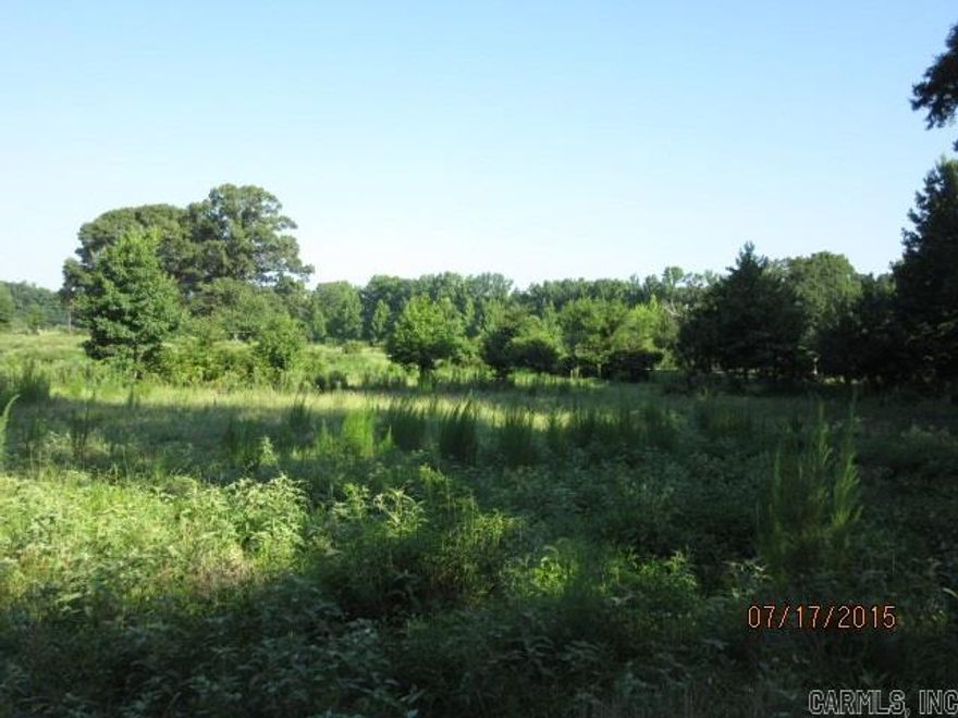 Rolling acres with pond. Some mature trees. Close to town on paved road. Utilities available. Cattle on property do not access unless accompanied by real estate agent.