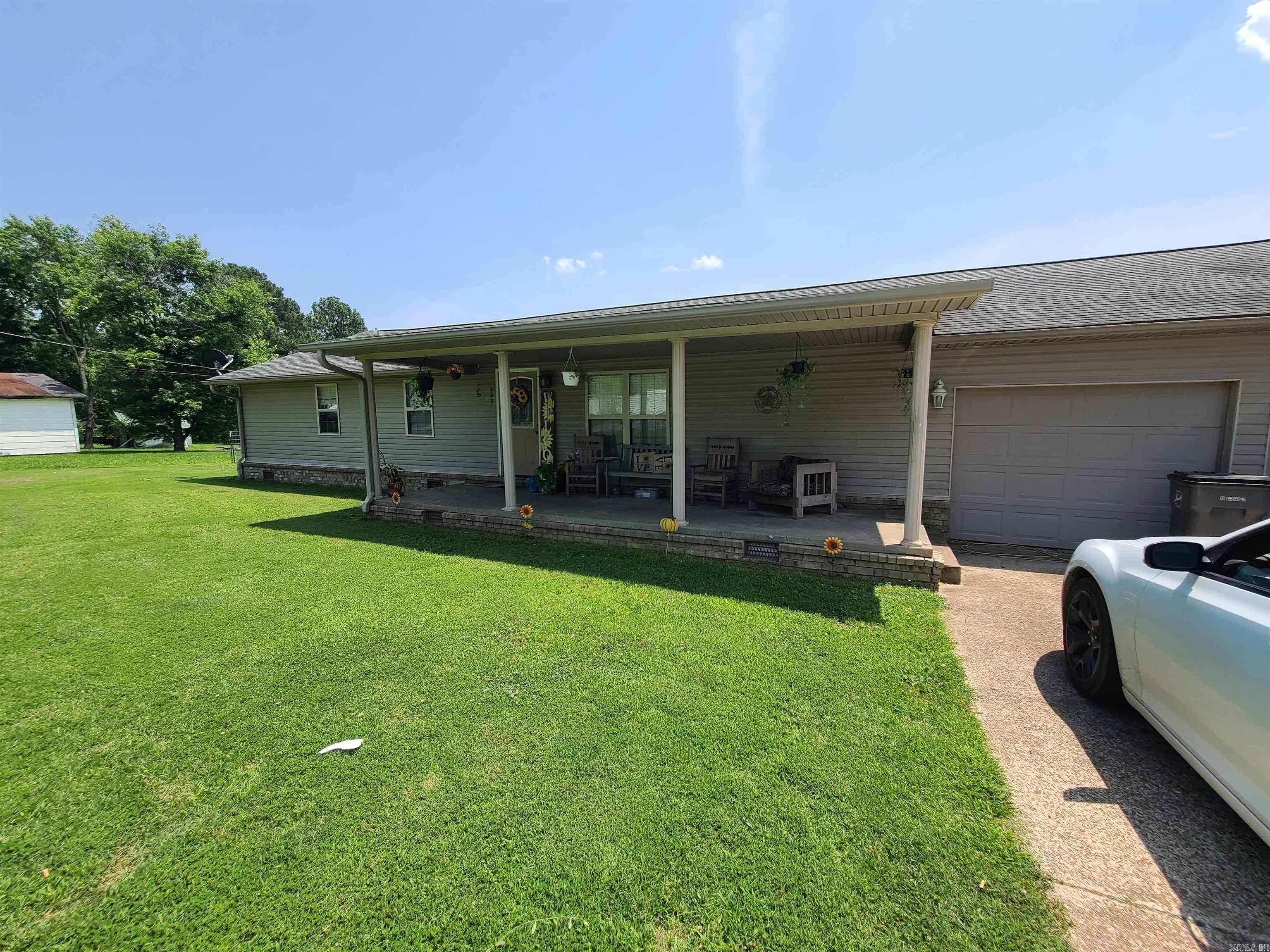 This charming, all-electric home features three bedrooms and two bathrooms, situated on a spacious 0.81-acre fenced lot. Its convenient location, less than a mile from Cedar Ridge Schools on a paved street. The home offers 1,456 square feet of comfortable living space and includes an attached two-car garage. Inside, you'll find an eat-in kitchen with ample cabinet space, perfect for family meals, and a living room boasting a double tray ceiling and recessed lighting, creating a bright and inviting atmosphere. The spacious master suite is a true retreat, complete with a walk-in closet, tiled bathroom floor, and a convenient tub/shower combo. The hall bath also features a dual vanity, tub/shower combo, and tile flooring. The exterior offers wonderful amenities, including an 8'x26' front porch, perfect for relaxing, and a large wooden deck in the back, ideal for enjoying the spacious fenced backyard in this tranquil neighborhood. This backyard is a major selling point, providing plenty of room for a garden, a shop, or just ample space for kids to play! The home also benefits from an air conditioning system that receives annual servicing by a licensed HVAC company, ensuring comfort.