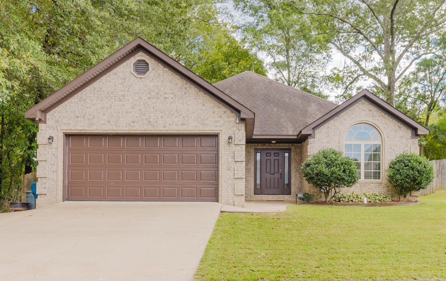 This cutie won't last long. Nestled in Bryant, this home has a great open floorplan with a modern look.  Hardwood/LVP/Tile flooring throughout. Woodburning fireplace, perfect for this winter. The primary suite has beautiful tray ceilings with access to the patio, double vanity, walk-in shower and jetted tub.  The backyard has tons of privacy with a covered patio, fully fenced with a wooden playset. This home is at the end of the street with an extra parking pad, in addition to the 2 car garage. RD Eligible. Don't miss out on this one!  Schedule your showing today!