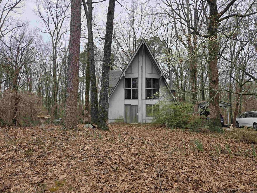 Tucked away among the trees on 2.25 acres, A-frame home offers the perfect blend of privacy and character. Located outside city limits, you’ll enjoy a peaceful, secluded setting while still being within reach of town. The unique layout features a cozy yet functional design, including an inviting upstairs retreat complete with its own private bathroom—ideal for guests or a primary suite. Step outside to relax or entertain around the above-ground pool, surrounded by nature. If you’re looking for a distinctive home with space to unwind and room to breathe, this house is a must-see!" This Property is sold "As Is".  Newer Roof, Newer A/C Unit, Generac Generator.