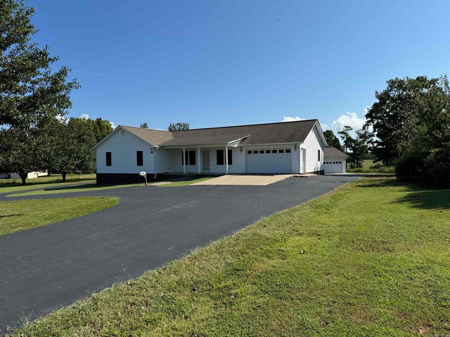 Enjoy Country lliving in this charming home. Very well kept and Handicap accessible. Master has tray ceiling, crown mold trim, walk in shower, and walk in closet. Large living room with tray ceiling and crown mold trim. Great location just outside of town. Paved Circle Driveway with nice garage.  Nice 24 x 30 shop with two RV hook ups. Plenty of room for boat, lake toys, yard equipment. etc. This is a must see and wont last long. Drive by and give us a call today.