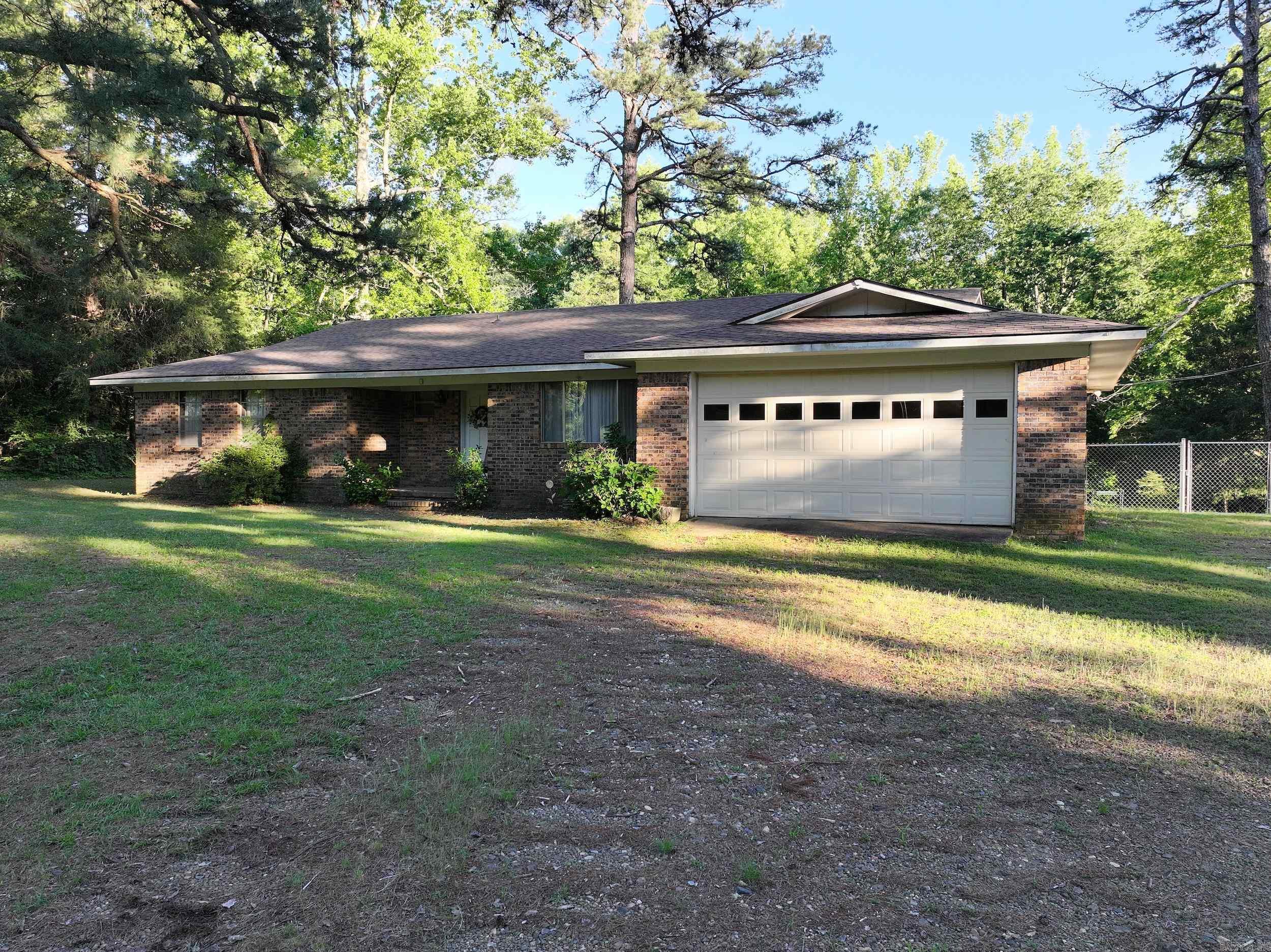 This spacious 3-bedroom, 2-bath brick ranch-style home offers approximately 2,580 sq ft of living space on 28± acres with a small creek—plenty of room to roam, explore, and enjoy the outdoors. Inside, the main level features updated flooring with new carpet and luxury vinyl installed in 2022. The kitchen includes a breakfast bar that opens to the dining area and cozy den with a fireplace, plus there’s a separate living room for added space. The primary suite boasts a walk-in closet and en suite bathroom. The walk-out basement expands your options with a game room, office, and two additional versatile rooms. This home is wired for fiber optic internet and offers ample storage throughout. Outside, relax on the open back porch, watch for local wildlife, and make the most of two large shops (20x30 and 20x25), a storage building, and a chain-link fenced backyard. A rare blend of comfort, space, and function in a country setting.