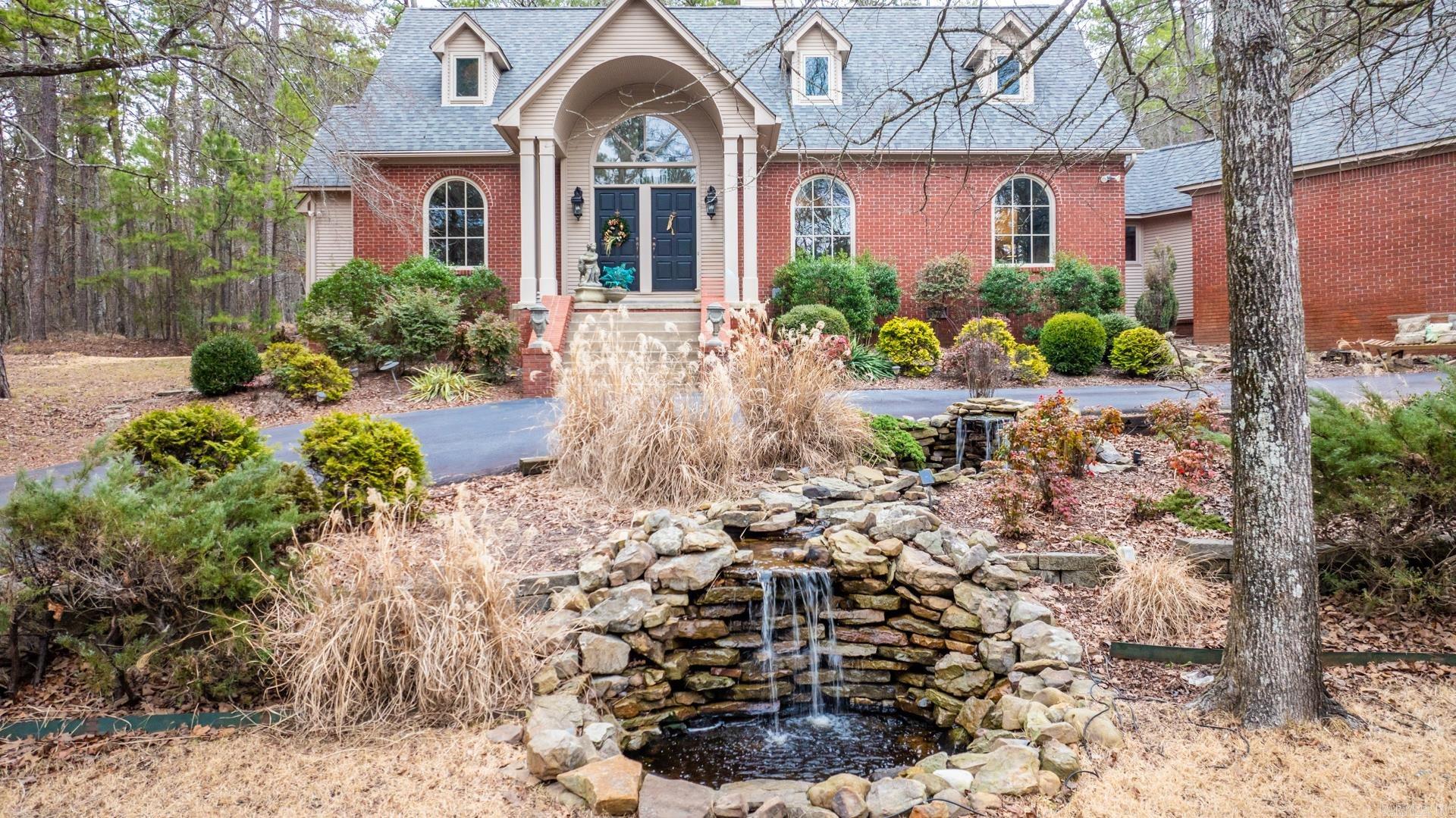 Take the gated driveway up to this country estate and enjoy the circle drive featuring a beautiful pond with water flowing on cascading rocks. Enjoy your on oasis with over 3 wooded acres. Looking further you will find a spa like landscaped pool with another waterfall feature just steps away from your back door. Attached 4 car carport located at the back of the home. Large 2000 sq. ft. metal shop building with room for all of your toys just past the pool. Home features 4 Bedrooms/3.5 Baths and the master bedroom is on the main level with a beautiful bathroom and jetted tub. The remainder of this home features formal dining, eat-in kitchen, living room, an office, and a game room not to mention the large laundry room with sink. A patio/deck off the kitchen for entertaining. A must see!