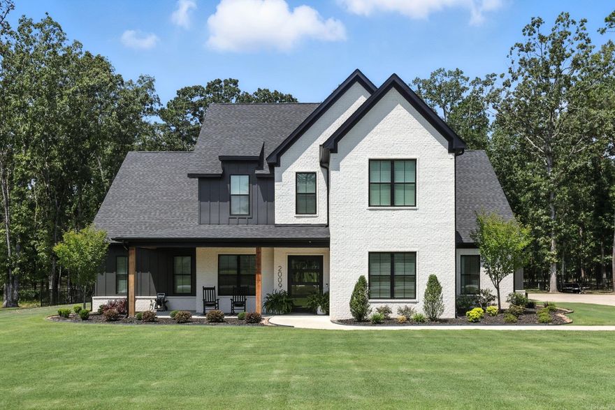 Step through the grand swivel iron door into an entry that sets the tone for this stunning custom home. The office features built-ins and modern French doors, while the living room offers a high-end gas fireplace, & built ins. The open flow into the dining area and gourmet kitchen is a dream. Kitchen offers custom cabinetry, two pantries, pot filler, drink fridge, and wood beam accents. The primary suite boasts wood beams, trey ceiling, spa-like bath with soaking tub, oversized shower, gold accents, and a spacious closet with built-ins. A second ensuite, large laundry, and half bath with patio access complete the main level. Upstairs includes two bedrooms, full bath, oversized bonus/movie room, and flex space- perfect for crafting, gaming or additional workspace. Outdoors, enjoy a full kitchen, expansive yard with wrought iron fencing, and side-load garage with extra parking. Added upgrades include custom blackout shades and fully encapsulated foam insulation. Truly custom at every turn! This modern beauty is meant to turn heads at every corner.