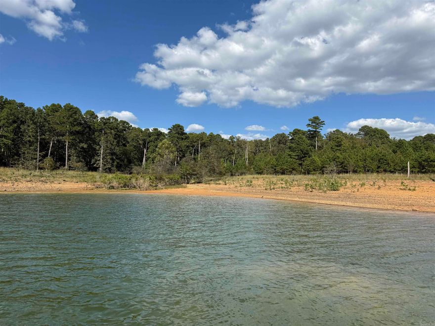 LAKEFRONT LIVING AT ITS BEST!  Discover the perfect spot to build your dream home on this beautiful one-acre lakefront lot nestled in a quiet, desirable subdivision.  With a low white line, clear some trees for your awesome view of the lake.  Enjoy easy access to the water with a gentle walk down to a beach area - ideal for swimming, relaxing, or launching your kayak.  Just minutes from the golf course too! Enjoy peaceful mornings by the water and afternoons on the fairway - the perfect blend of lake life and leisure.  Your lakeside escape awaits!