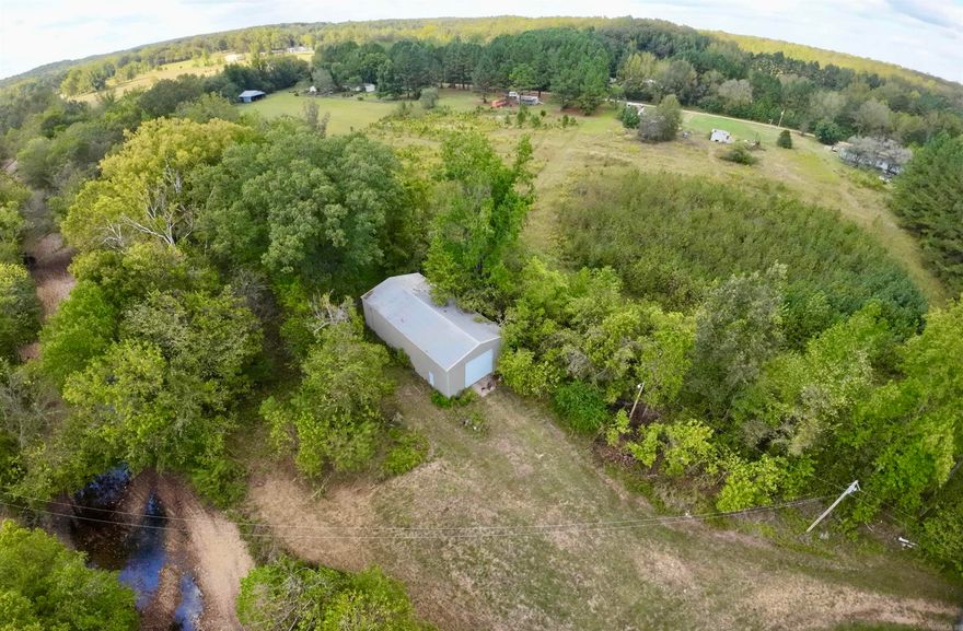 Unique opportunity with land and a large metal building. The beautiful private setting for this 2.89 Acres with approximately 800ft of creek frontage is ideal. The property boasts a large 1800 sq ft 30'x60' metal building with concrete floors, electric service, and 14 foot dooors on each end. This building offer tons of potential for uses for storage, your personal mechanic shop, farm equipment storage, or even as a shell for a barndominium. Water is available only a short distance at the county road. Agent owned.