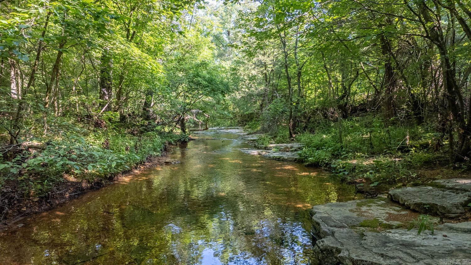 Escape the hustle and settle into 40 wooded acres of peace and privacy in Ravenden, Arkansas. Just outside of town, this scenic property is accessed via a well-maintained dirt road, with public creek access nearby—perfect for fishing, relaxing, or kayaking. The land features stunning natural rock formations, a winding cleared path ready to become your driveway, and a private hilltop clearing ideal for your future home or getaway cabin. A year-round creek flows through the corner of the property, enhancing the tranquility and charm. With neighbors spaced far apart, you’ll enjoy seclusion, starry skies, and the calming sounds of nature. Whether you're envisioning a weekend retreat, hunting property, or a full-time residence, this buildable tract offers incredible potential. Listed at $140,000, it’s a rare chance to own acreage with character, beauty, and convenience. Come walk it and picture your future here—your Arkansas hideaway awaits.