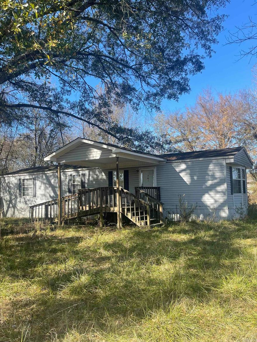 This tract has app. 440 ft of frontage on Newberry Road. The mobile home conveys at no value, but could be livable with some work. Property is sold with no disclosure "as is where is".