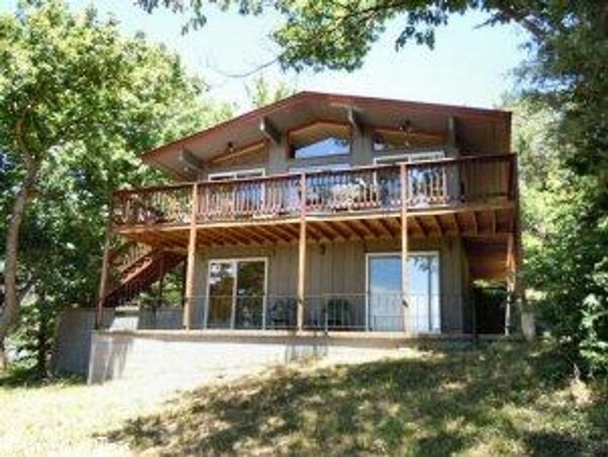 TOP OF THE WORLD SUNSETS! Tranquil evenings on the deck offer beautiful distant views of Cherokee Village lakes and river. Remodeled with new cabinets & counter tops, lighting fixtures, and flooring. The main level has the open living room/dining area/kitchen with vaulted ceiling and large windows all across to take advantage of the Ozarks view. Downstairs are the two bedrooms, full bath, laundry room and patio.  This has been on the nightly rental program and would be a great investment/holiday get-away.