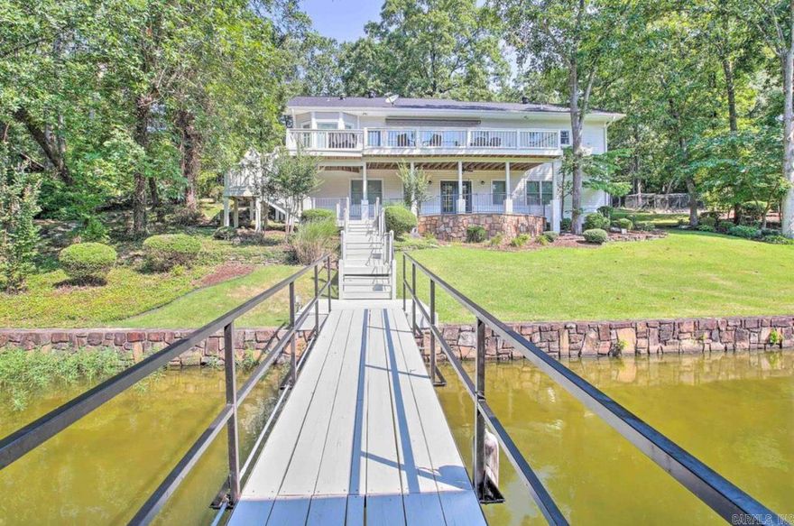 Beautiful, breathtaking property located on the water’s edge of Lake Hamilton!  This stunning home leaves nothing to be desired. Featuring FIVE bedrooms and THREE full bathrooms, this home has plenty of room. The large living area and kitchen provide plenty of space for hosting guests! Stunning new designs throughout the home inside and out make it a sought after property on the lake! Tired from a day on the lake? Your master suite shower has a steam option turning it into a relaxing sauna! The whole home generator is an added bonus for peace of mind. Downstairs you will find an open area living space, along with a wet bar, one bedroom, and one full bathroom. Step out onto your spacious upstairs deck for a relaxing evening by the lake. Enjoy the huge backyard by sitting at your fire pit just feet from your 175 feet of lake frontage! Enjoy your own covered boat dock for easy access to everything that Lake Hamilton has to offer. A separate 975 sqft garage offers plenty of space for parking or storage and also has a shop area located inside. This property also boasts an outstanding investment opportunity in the booming short-term rental market. A highly profitable property for sale!