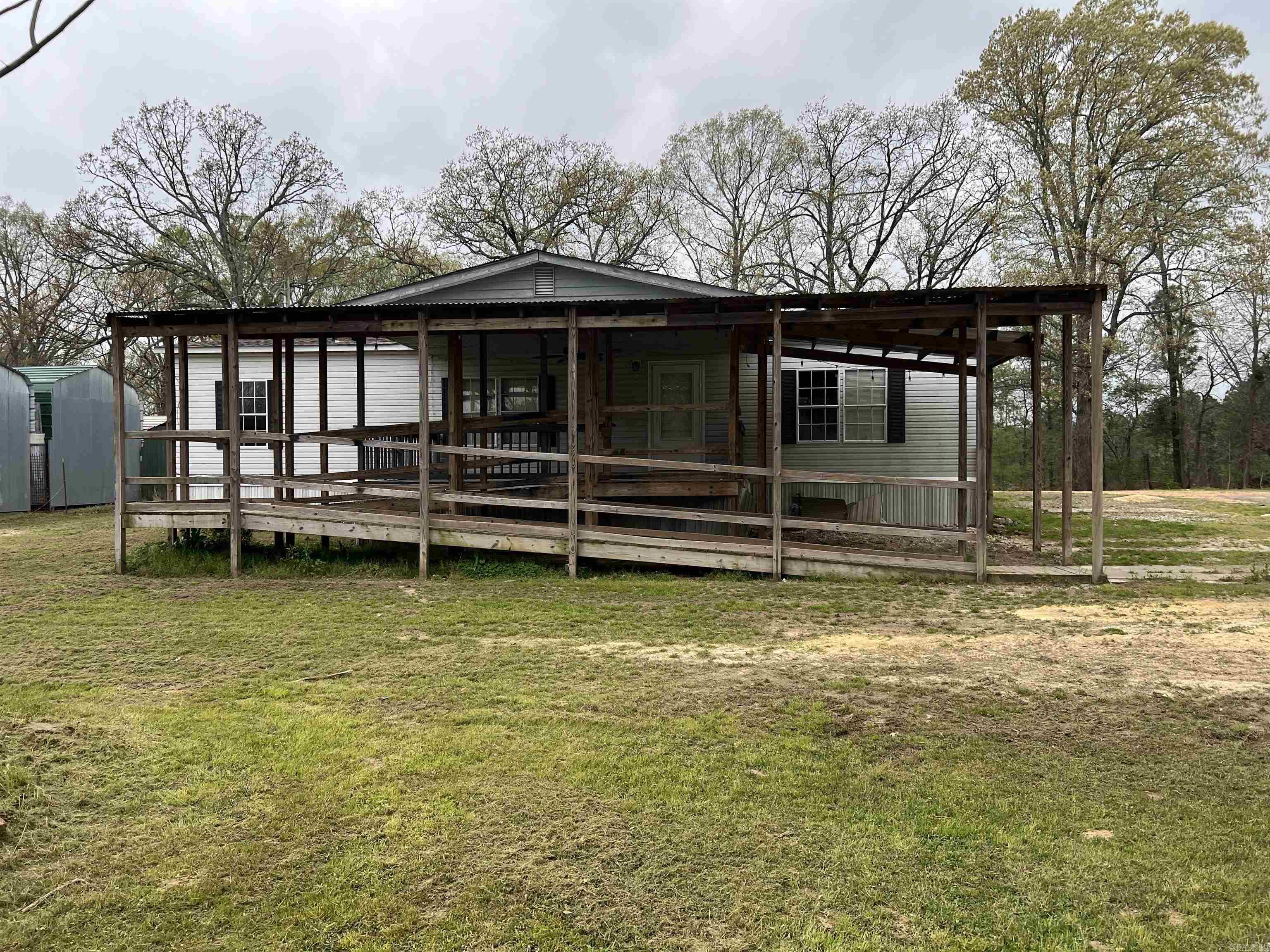This property, located in a great area has a lot of potential. This 3 bed, 2 bath manufactured home has a split floor plan with the master and bath on the opposite side of home from the secondary bedrooms. There is an ADA ramp leading onto the large front porch with covered parking for 1 vehicle located in this area as well. There is also a large detached carport located behind the home. This home sits on just over 3 acres of land just south of Benton. Call or text us to schedule your tour and see all of the possibilities of this home. Motivated Seller! Property is to be sold As Is.