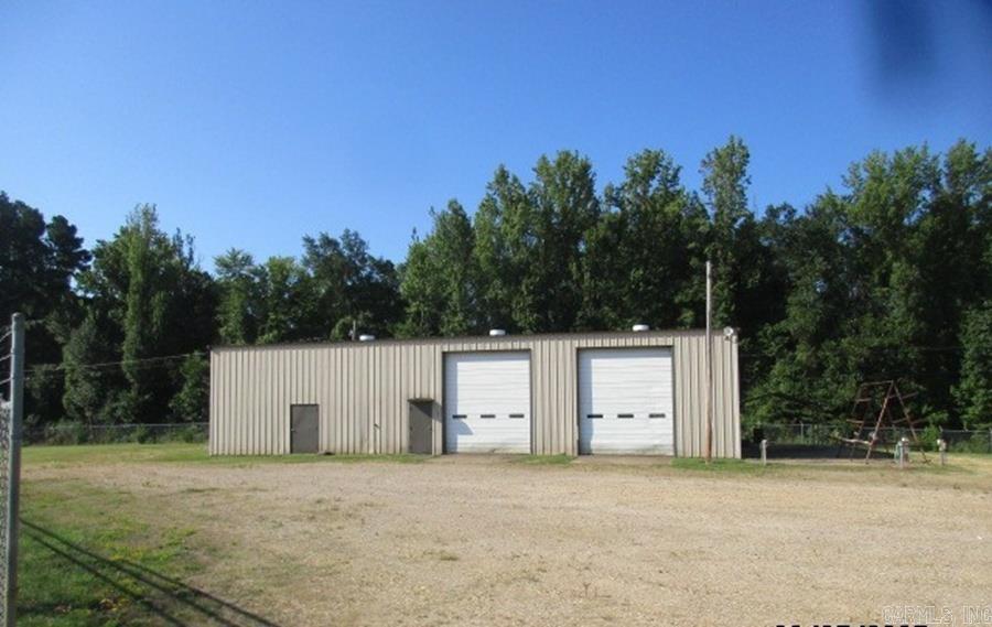 This shop sits on 1.39 acres that is fenced with a gate. Two roll up doors on the front, one roll up door on the back. The shop has a concrete wash rack. There is office, bathroom and parts room downstairs. Upstairs offers loft space. Lights have been updated to LED lighting. Service air is piped with drops. Don't miss this great buy right by the new Dollar General and across the street from the Kingsland School.