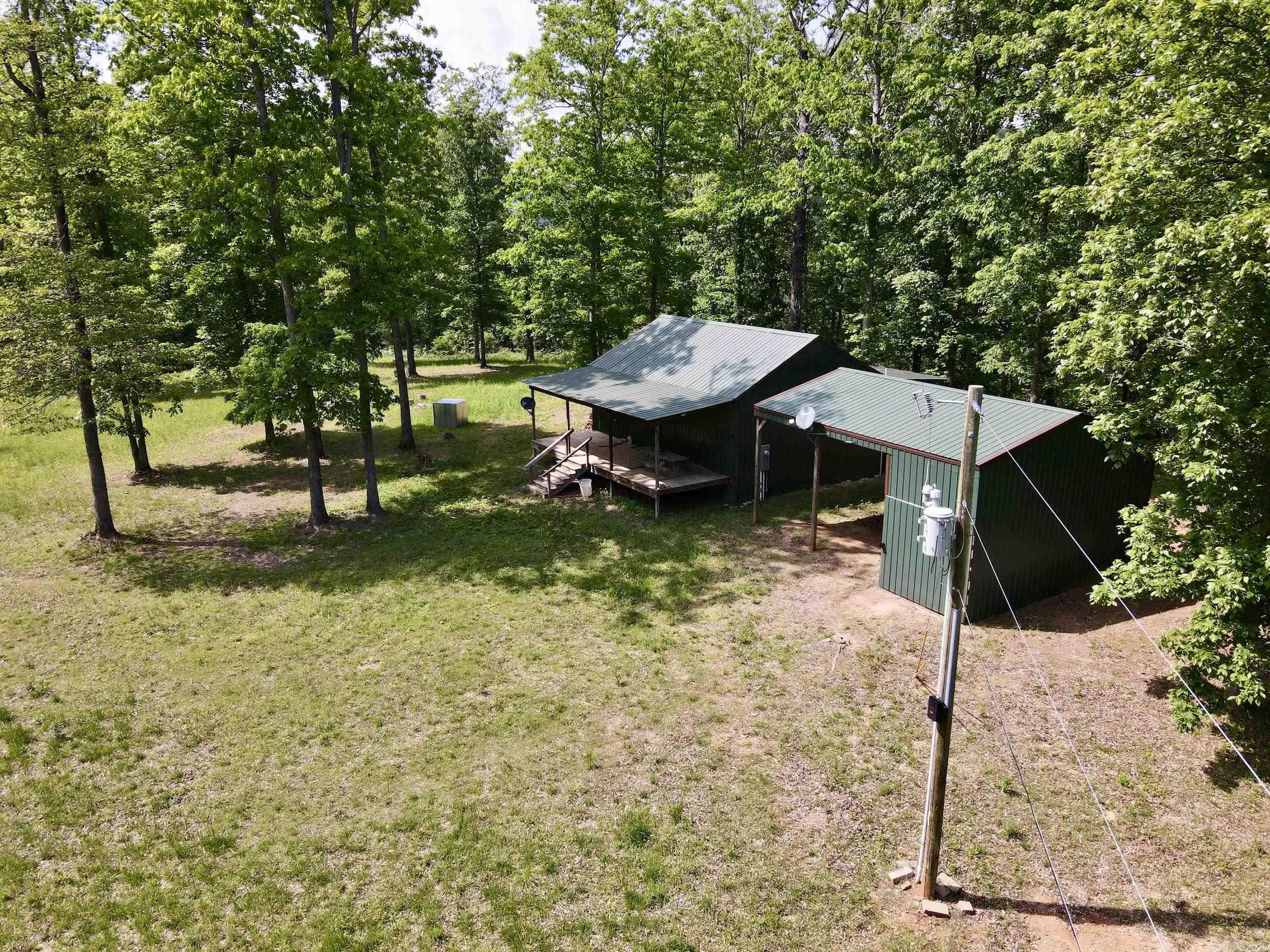 Properties like this are truly rare! Tucked away at the end of a gated Forest Service road, this charming 2-bedroom, 1-bath cabin offers the perfect combination of modern comforts and remote seclusion. With electricity, water, and Wi-Fi, you’ll enjoy the conveniences of home while being immersed in the tranquility of nature. Relax on the large porches at the front and back of the cabin, where the only sounds are the soothing flow of nearby creeks and the chorus of the surrounding forest. A pole barn provides ample storage for recreational toys or doubles as a pavilion for entertaining guests. Explore the property via well-maintained trails that lead to multiple creeks, waterfalls, and your choice of 5 strategically placed, high-quality box blinds for deer hunting. The landscape features mature hardwood timber, fields, and thickets that create a haven for abundant wildlife, including deer, bear, turkey, and even the occasional hog. Whether you’re hunting, hiking, or simply seeking a peaceful escape, this property offers unmatched opportunities to experience the beauty of the Arkansas outdoors. Don’t miss this rare opportunity to own a cabin retreat that truly has it all.