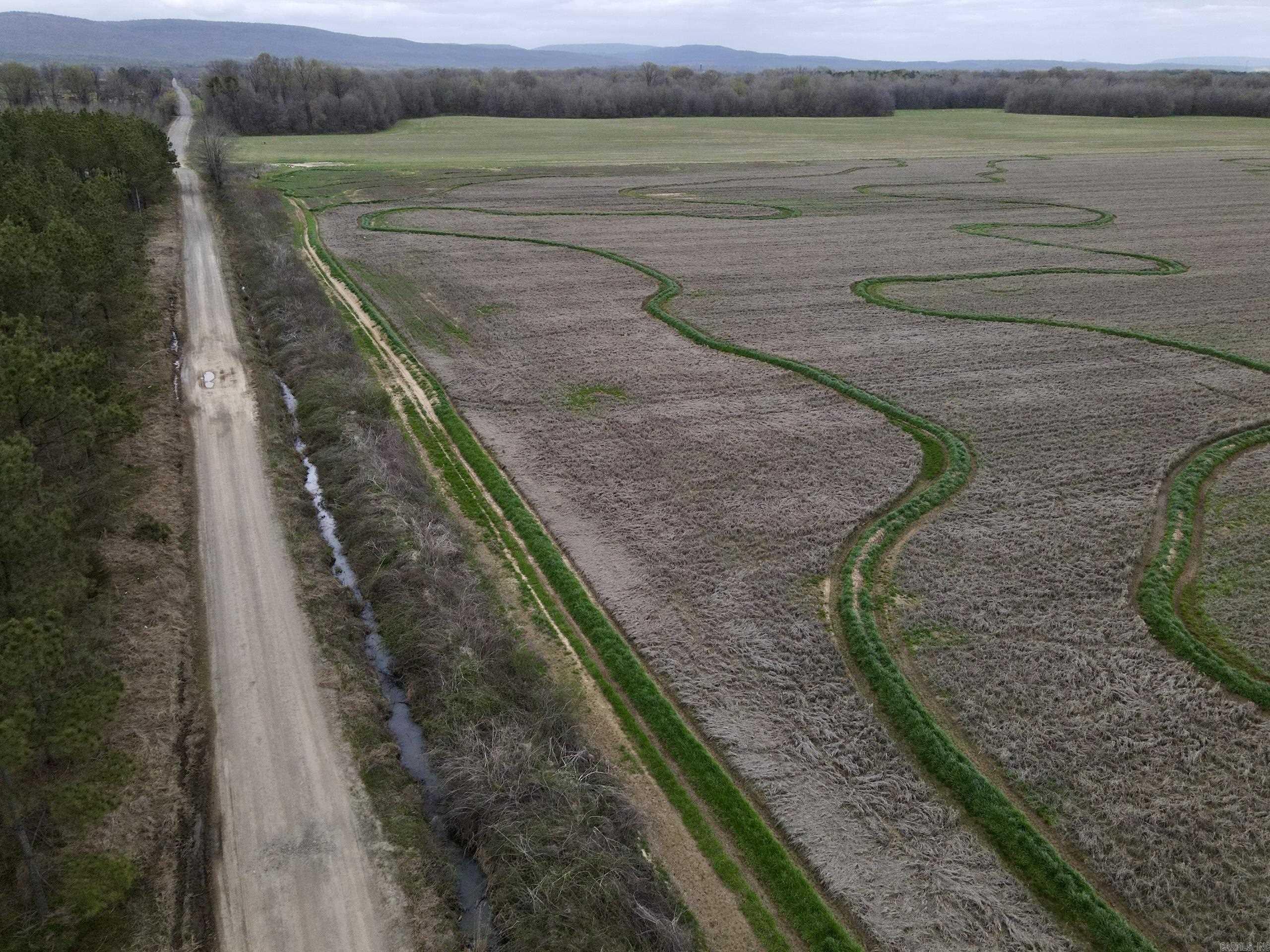 This high-producing agricultural property boasts a proven track record of success with established irrigation for rice, soybeans, corn, and wheat. Three risers draw water directly from the Petit Jean River, ensuring reliable irrigation and consistent yields. With its fertile soil and efficient irrigation system, the land also holds potential for hay production. The property features approximately one-half a mile of county road frontage for easy access and nearly one mile of Big Piney Creek flowing through it. The creek is lined with mature timber, providing excellent fishing and creating an ideal wildlife habitat for deer and turkey. Located just minutes from Mount Magazine State Park, the U.S. National Forest, Blue Mountain Lake, and the Petit Jean River, this property offers not only agricultural value but also prime recreational opportunities. Income Potential ā The seller is open to leasing back the property for cash rent, providing a strong return on investment (ROI) for the next owner. A rare opportunity to own a productive farm with recreational appeal and income potential!