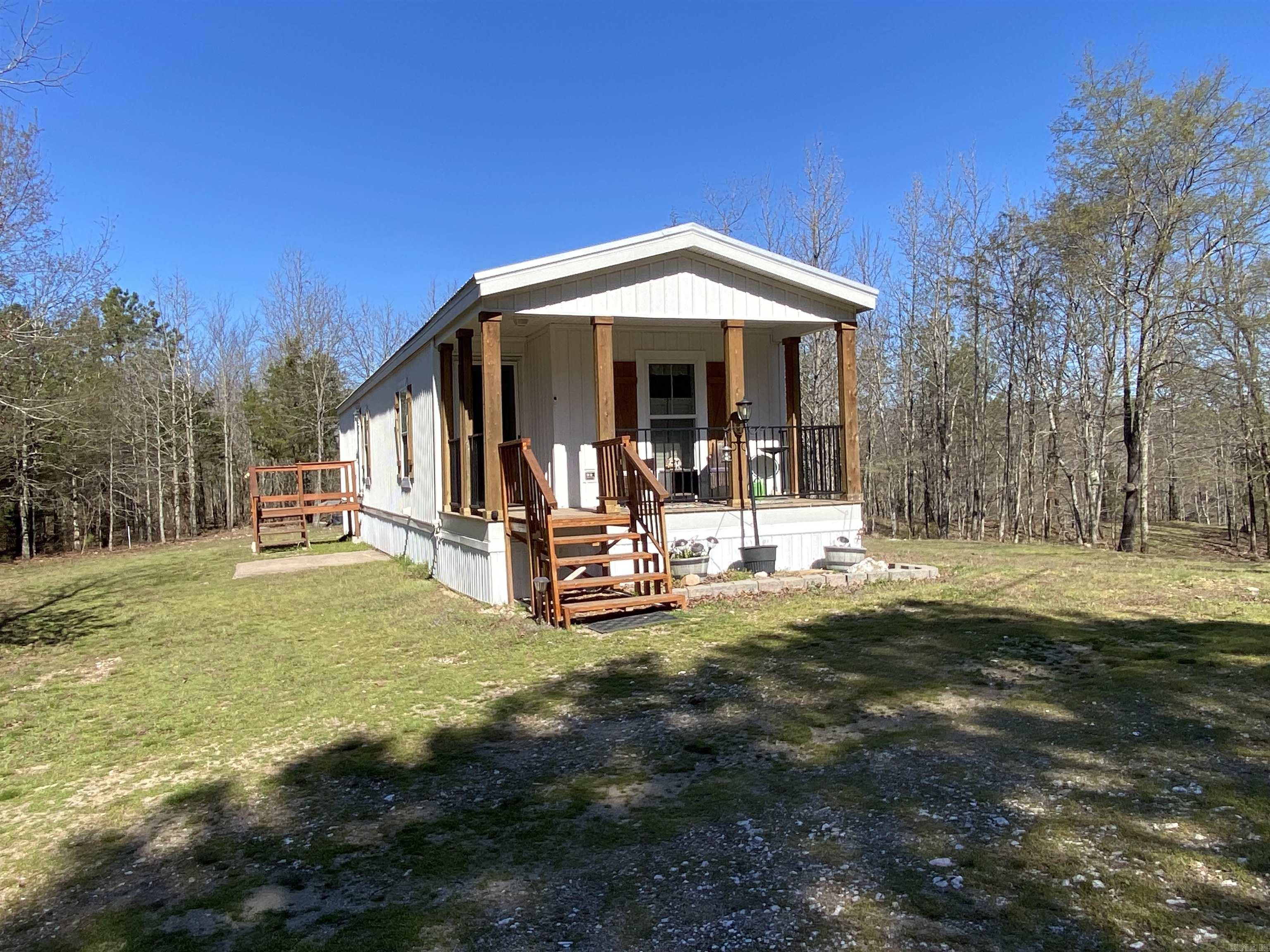 Searching for a relaxing place to get away from it all? Look no further than 48 Wildlife Lane in Mount Ida! Just a few miles to launch your boat on beautiful Lake Ouachita with a 26'x35' covered spot for boat or RV/camper storage. A 2022 Sunshine Manufactured home featuring 2 bedrooms and 2 baths decked out with modern fixtures, stainless steel appliances, & a covered porch to enjoy at the end of a long day. The 3.01 acre m/l parcel is wooded with a walking trail down to your shared pond and lots of signs of wildlife around. There is a 12'x24' lofted (for storage) barn built to handle the weight of a car or your mower. A storm cellar is located just out the front door a bit for your safety during a storm. This home is selling furnished. Just bring your personal items and begin relaxing today! $199,000.00