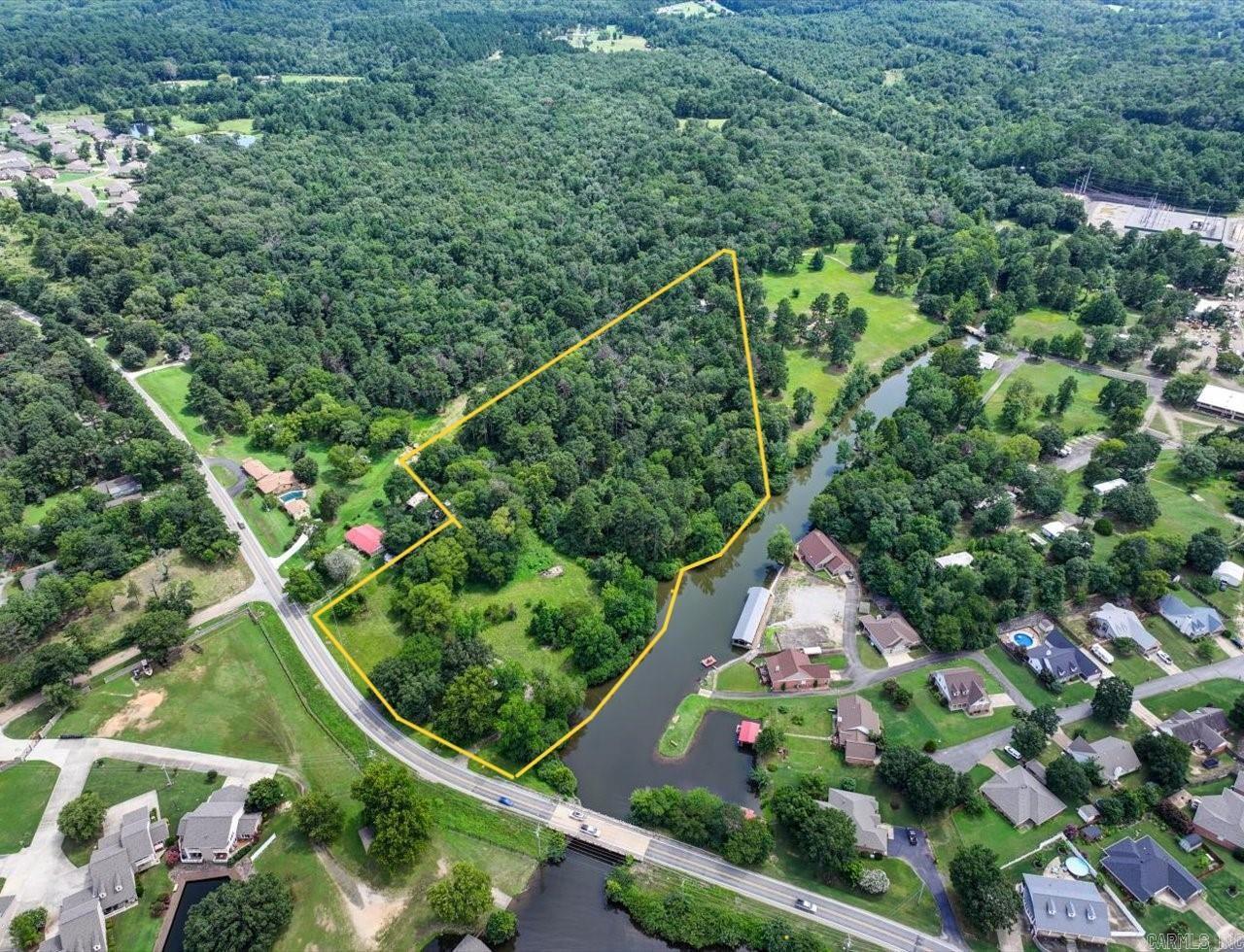 ATTENTION DEVELOPERS - RARE LAKEFRONT OPPORTUNITY! This is one of the last big parcels of land on Lake Hamilton for development. +/-12.45 acres with +/- 950 feet (est.) of lake frontage in the highly sought after HWY 7 South corridor, with over 350 feet of frontage on HWY 290. This prime property is located in Lakeside School District and all utilities are at the highway. Land is flat with two beautiful inlets surrounded by mature oak and pine treesācreating a serene and picturesque setting for your next development. This is the best parcel of lakefront property in a while. Whether you're envisioning lakefront homes, a resort-style community, or a private retreat, the possibilities are endless. Opportunities like this donāt come around oftenāschedule a visit and see for yourself why this is one of the best parcels to hit the market in years! There is a mobile home and outbuilding on the property, but the value is in the land and there is one sewer pump for the mobile home.