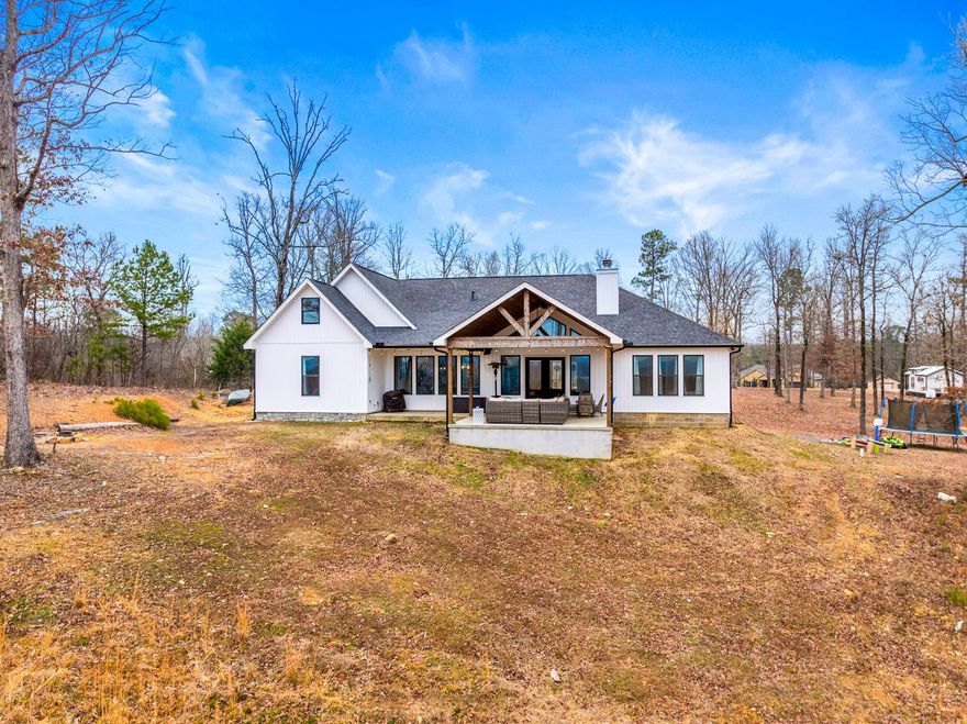 Land, Creek, Views & Newer Construction – Country Living at Its Best!  Enjoy serene country living with easy access to Lake Ouachita, Lake Hamilton, dining, and shopping! Just 5 miles to Lake Hamilton School, and quick routes via airport or 270 to avoid traffic.  This 3,700 sq. ft. home features 10 ft. ceilings throughout with a gorgeous vaulted ceiling in the living room. Expansive back porch and front porch for ultimate outdoor living wrapped in beautiful tongue and groove ceilings. Large pantry for food storage and a custom hidden safe room!   Additional 40x60 shop pad with utilities where a tiny home sits (can be purchased separately or moved by seller). Oversized 2-car garage, hybrid HVAC system (gas & electric), gas stove/fireplace, marble & leathered granite countertops.  Wired for a generator, plus gas line for outdoor kitchen hookups and fast hot water with a recirculating pump.  The creek is fishable, and the land beyond is perfect for hunting deer or turkey. A rare opportunity to own a modern, peaceful retreat with all the conveniences!  Purchase the Guest Quarters for an additional rental income, or more room for family! The tiny home is 1 bedroom, 1 bathroom.