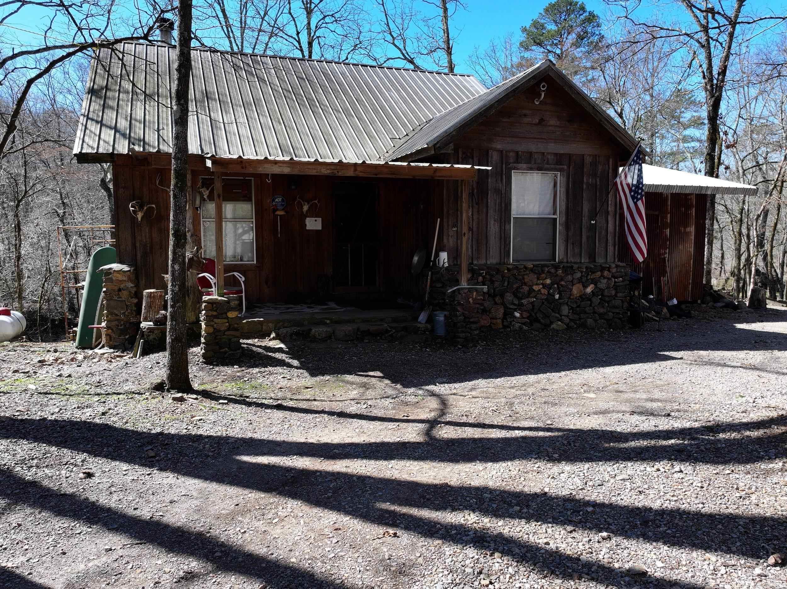 Riverfront Cabin in the Ouachita National Forest Nestled on 3± acres in the Ouachita National Forest, this custom-built 3-bedroom, 2-bathroom cabin offers 165± feet of frontage on the Southfork of the Caddo River. With stunning views and access to outdoor activities such as fishing and hunting, this property is a great opportunity for those who enjoy the outdoors. Inside, handcrafted finishes and a wood-burning stove add warmth and character. The open floor plan seamlessly connects the living area to a spacious kitchen, creating a functional and inviting space. A large deck overlooking the river provides a perfect spot to relax or entertain. The property also includes a 20x30 shop, a shed, and covered parking, ensuring plenty of space for storage and projects. All-new windows enhance the home’s appeal. Conveniently located within driving distance of Little Missouri Falls, Hot Springs, area lakes, and Crystal Mines, this property is a great option for a weekend retreat or a full-time residence.
