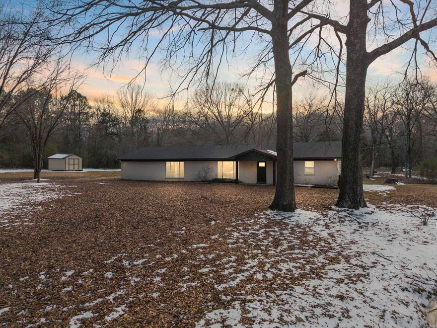 Oh. My. Remodel!!!!! This 3 bedroom 2 bath home was taken down to the STUDS in 2021!!!!  HVAC, roof, windows, and tankless water heater were all replaced in addition to the entire interior design! This home offers the best of both worlds: SERENE privacy on 5 acres and MODERN living with custom finishes. The rock fireplace, surrounded by built-ins, is the focal point of the oversized living room. The kitchen has beautiful granite countertops, upgraded CAFE' appliances, a gas range, and a single basin sink that looks out across the peaceful backyard. The primary suite is a RETREAT, to say the least, with a generous sized bedroom, walk-in closet with a dresser-island (that is DREAMY), and a spa-like bathroom that you will have to see to believe. Hello rain shower and huge soaking tub!!! The split floor plan has 2 additional bedrooms with great storage and the other bathroom with granite countertops, double vanities, and a walk-in shower. The backporch offers a place to relax and enjoy with the wood-slat celiings and fan to cool you off on hot days! . If you're looking for a home that combines quality craftsmanship, modern design, and peaceful surroundings, here is your sign!!