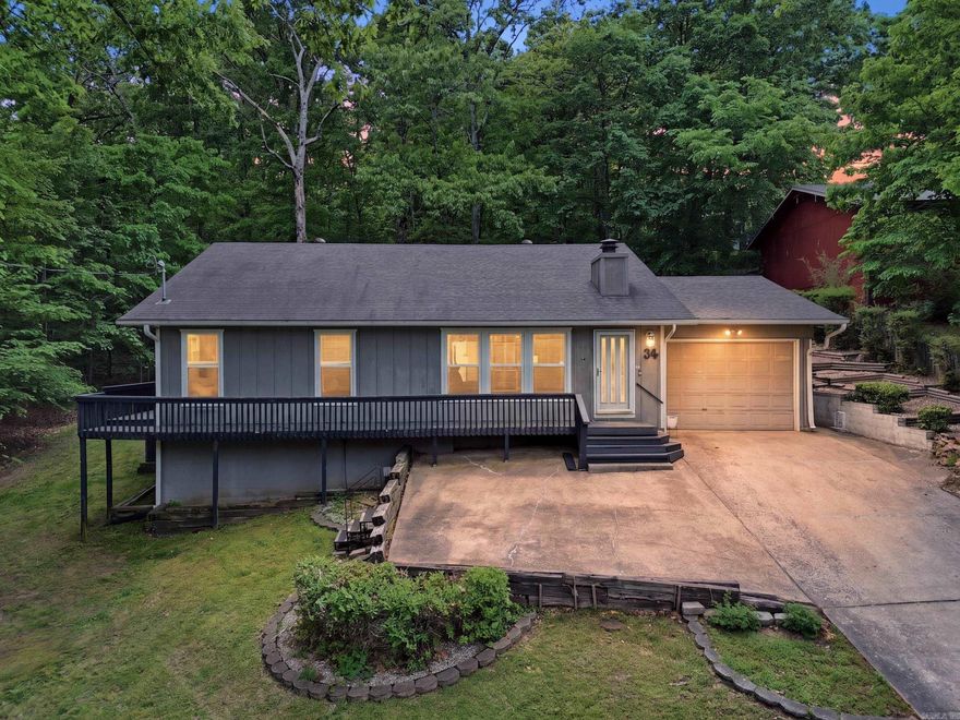 Beautiful home featuring two master bedrooms. The open-concept design includes a cozy fireplace and stylish laminate flooring throughout. The kitchen stands out with custom walnut cabinets, elegant white marble countertops, and high-quality appliances. Recessed lighting and numerous windows create a bright, airy atmosphere. Enjoy a wrap-around deck that offers outdoor access from both bedrooms. The oversized one-car garage complements tasteful landscaping and a private backyard that backs up to the woods, enhancing your outdoor living space.  Ideally located less than two minutes from the Bella Vista Recreational Center, Kingsdale Tennis Center, Kingswood Golf Course, and Berksdale Golf Course, this property offers both convenience and lifestyle. Whether you're looking for a fantastic Airbnb/VRBO investment, a first-time home, or the perfect place to downsize, this home checks all the boxes. Schedule your showing today!