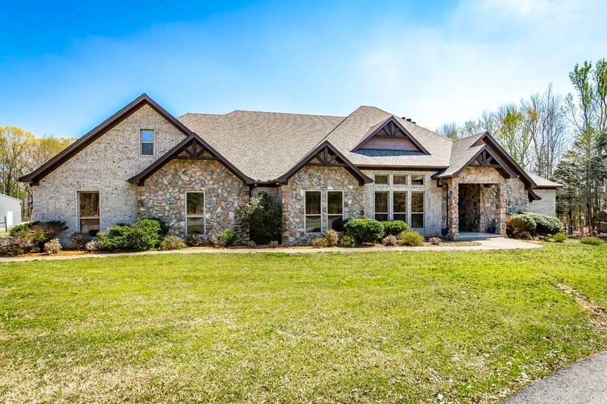 Come home to this gorgeous country estate on 18 acres, already set up for your animals! This luxuriously appointed home allows for you to live your homesteading dreams while still enjoying all the creature comforts! 12-foot ceilings, beautiful hardwood floors and granite countertops throughout. Primary suite boasts its own private fireplace, tray ceilings, a custom walk-in double shower as well as a 2-person jetted tub along with a massive closet. Each bedroom has its own en-suite bathroom, giving each member of your family their privacy. F-4 tornado rated safe room off the kitchen than can double as a home office or study with barn doors. Mud room entry from garage and large laundry area. Kitchen includes double convection ovens, under counter ice maker, and instant hot water dispenser at the sink. 3 separate HVAC units and 2 water heaters (80gal and 50 gal) to keep everyone in this home happy and comfortable! New roof installed in 2023! Fenced back yard for pets, large covered patio for entertaining or relaxing, 3 stall barn with attached paddock and riding arena along with separate pasture area with solar electric fence.