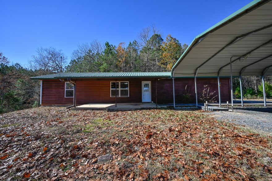 Discover the perfect blend of space and outdoor recreation with this cabin on 4+/- wooded acres near the Ouachita National Forest and convenient ATV riding areas. Inside features include a large bedroom with a walk-in closet, full-size washer and dryer, wood accents, log-style siding, and a spacious full bathroom. The property also includes a two-car garage, a like-new metal carport, and an in-ground storm shelter under the carport equipped with a bed and microwave. The land is gently elevated with trees creating a natural wooded backdrop, along with a small fenced pasture area suitable for livestock or a starter homestead, and a poured slab ideal for creating an outdoor hangout space. Nearby creeks offer additional outdoor enjoyment, making this property suitable for either full-time living or a weekend getaway close to recreation.