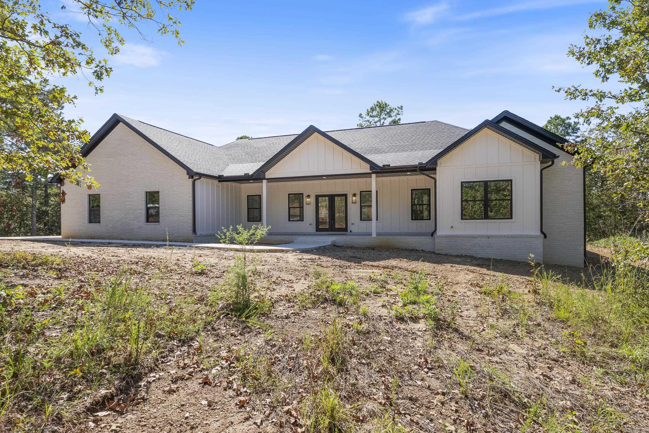 Stunning new construction home that is tucked away in the trees. Luxurious finishes throughout, and a lovely floor plan that is perfect for gathering with friends and families. The wow factor begins at with the large front porch where you can enjoy your morning coffee. The exterior Snowbound board and batten matches well with the Tricorn Black doors and black windows. As you step inside, there's a spacious dining area with a gorgeous chandelier and accent wall. The large kitchen features curated quartz countertops, quartz backsplash, custom cabinets, and a huge butler's pantry! The kitchen island provides plenty of storage and seating for large groups. Hand scraped hickory wood floors give the home elegance. The living room is tied together with a beautiful fireplace and custom wood beams in the ceiling. The 18' x 17.5' primary suite has plenty of natural light, a large walk-in closet, and 2 charging ports on the accent wall. The ensuite bathroom features a soaking tub, rectangular porcelain tile, and custom shower. 2 large extra bedrooms, and a flex space that could be an office, nursery, dog room or more. Big back patio for BBQ's and relaxing! Some photos are virtually staged.