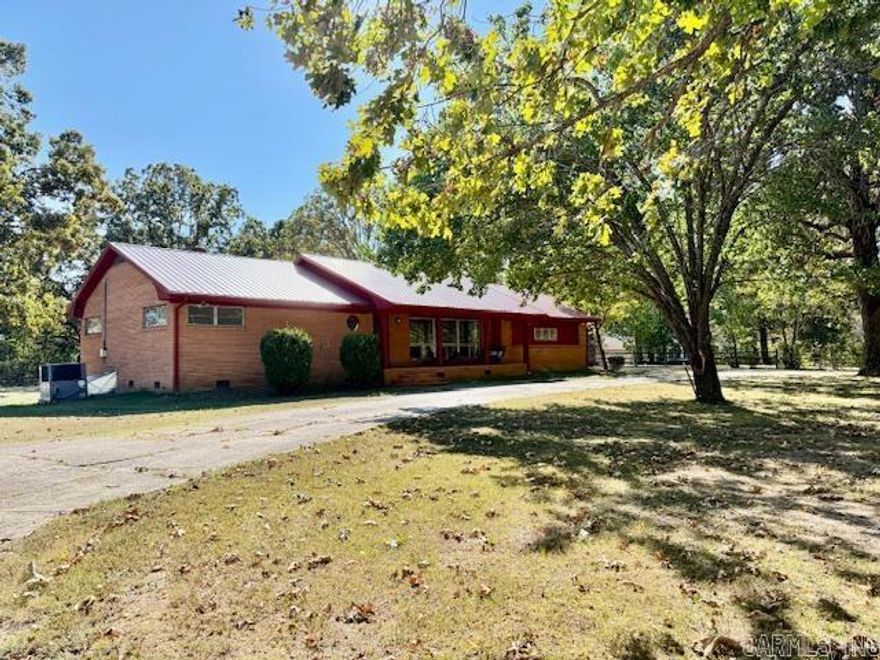 A long circle drive leads you through stately Oaks & Pines to this well-kept residence with timeless curb appeal. The covered front porch offers a peaceful place to sit on the porch swing. Step inside & the gorgeous hardwood floors shine with light from the huge windows in the living room. The kitchen is always the heart of the home! Enjoy abundant wood cabinetry & a center island with bar seating as well as nice built-ins. Whether cooking, dining, or relaxing by the fire this area effortlessly blends function & comfort for everyday living. Storage is abundant here: all closets are large & cedar lined. There are 2 bonus rooms at the back, perfect for having a separate office/hobby room. The laundry room is large & has an incredible double soaking sink. The property offers expansive open level yard space at the back for outdoor living, gardening or adding a shop or a pool. Enjoy grilling outside on the concrete patio. Parking will never be an issue here with all of the paved parking space & driveway. There is an attached double carport at the back of the house near back door with a storage room & a separate storage building with concrete floor.
