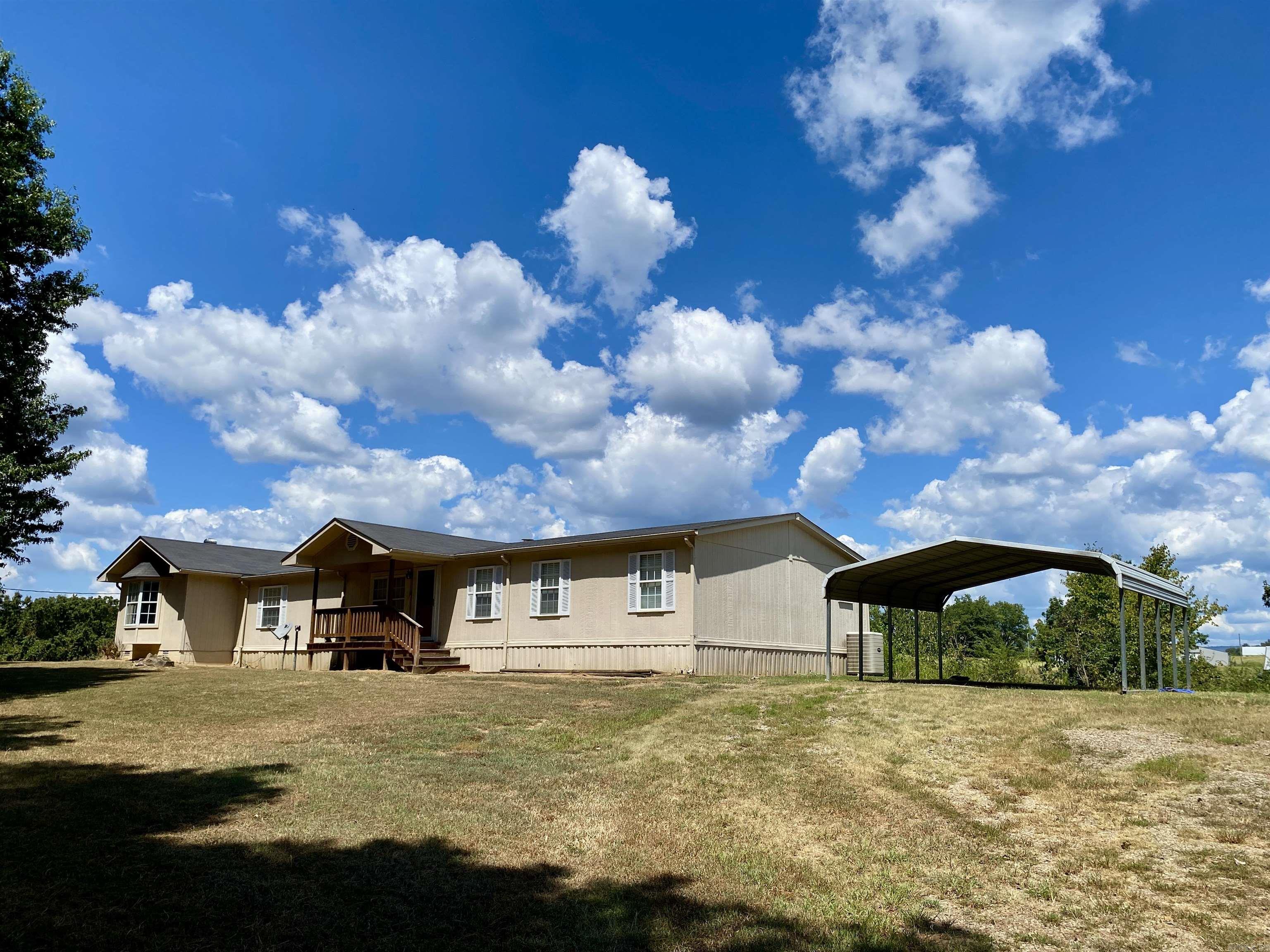 This well-maintained 4BR/3BA manufactured home underwent a major remodel in 2016 featuring a new roof, HVAC, windows, insulation, cherry cabinets, and doors. Inside, enjoy open living, dining, and den areas with vaulted ceilings and a cozy wood-burning fireplace. The fully equipped kitchen offers abundant cabinetry, a breakfast bar, and pantry. Step outside to the rear sun deck and take in the privacyāno neighbors nearby. Additional highlights include spacious bedrooms with ample closets, a separate laundry room (washer, dryer, and freezer convey), double carport, two HVAC units, and two water heaters. Surrounded by a grove of pine trees, this property blends comfort, space, and seclusion.