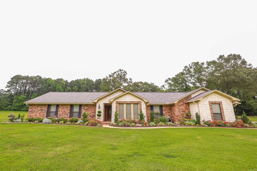 Welcome to your dream home nestled in the heart of a sought-after neighborhood, meticulously kept inside and out!  This charming brick home boasts an inviting exterior adorned with azaleas, roses, and an array of perennials & annuals, creating a vibrant burst of colors year-round. Step inside to discover the epitome of craftsmanship, with hand-crafted cabinets, matching appliances, and elegant granite countertops adorning the kitchen which overflows into an ample laundry & pantry, ensuring convenience and functionality for your everyday needs. Relax and unwind in the sunroom, overlooking the lush yard, where a back patio beckons for al fresco dining and entertaining amidst the picturesque landscape. Stay cozy during cooler evenings with a pellet stove, adding warmth and ambiance to the living space. Solid surface flooring throughout enhances the home's allure, complementing the versatile layout, ideal for accommodating family and guests with ease.  The main en-suite offers luxurious space with double walk-in closets and oversized bathroom.  A large shop provides ample storage space, completing this perfect retreat for those who appreciate both luxury and practicality.