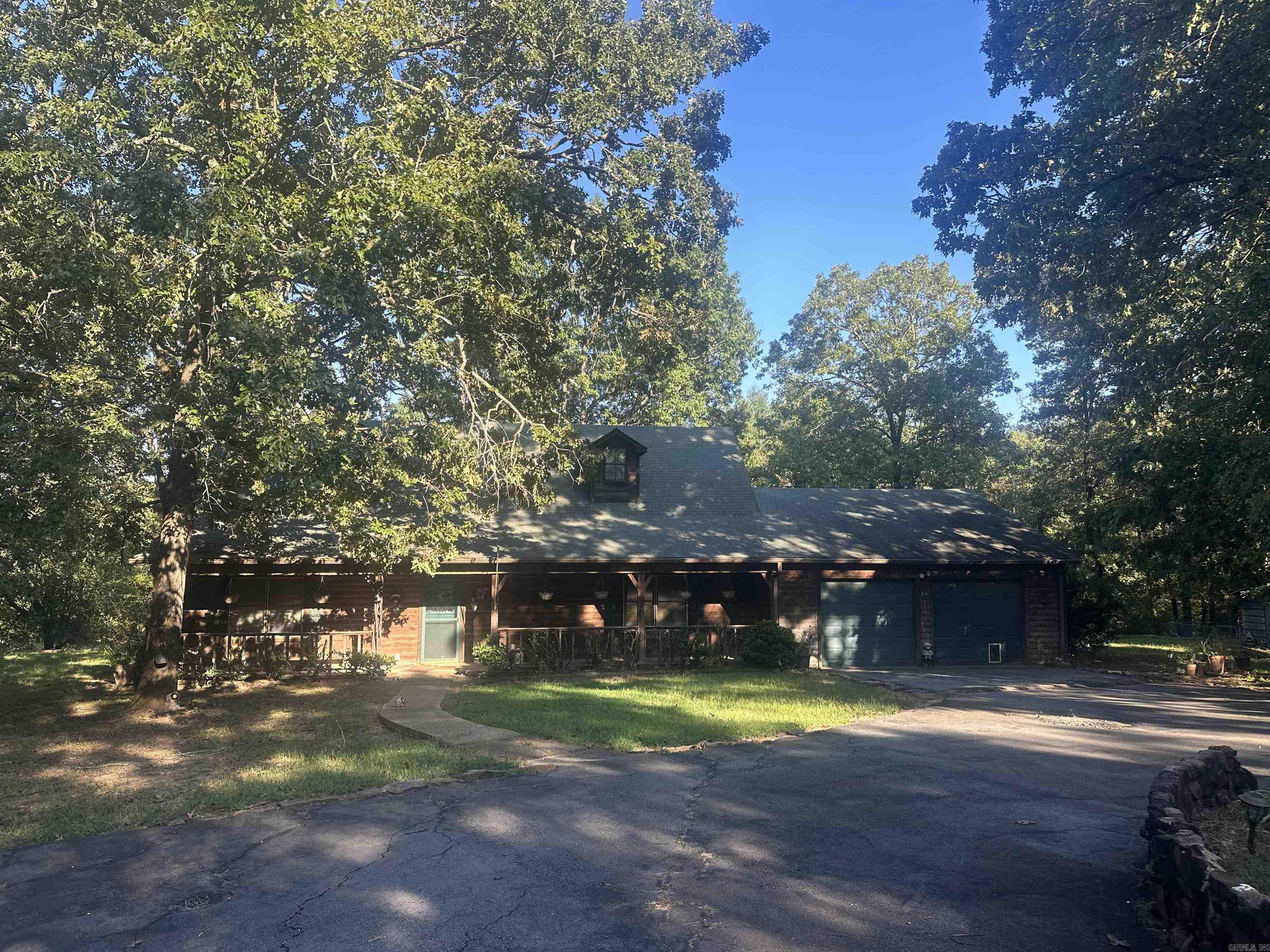 Rustic home built in the midst of trees and nature! Pond on the back of acreage with walkway to a gazebo! About 2 acres of property is fenced and home is very secluded and private but neighbors nearby! Cedar sided home with 2 car garage, well on property for yard care and home has city water.. Enjoy the beautiful wood design work encompassing the fireplace all the way to the cathedral ceiling-definately the focal point of the house! Stained kitchen cabinetry in kitchen with tile flooring that opens to dining area. Primary bedroom on main level with lots of linen space and jetted tub/shower in private bath. Hall bath and guest bath on main level also. Office space also-perfect for those that work from home. Upstairs is HUGE w/bedroom and a walk in closet that has hidden space! Bed & dresser stays with home. Roof replaced in 2008 and recently inspected. Vents cleaned and FP updated 2018. HVAC serviced June 2024. Propane wall heater in living room for extra comfort. Enjoy the attic fan during spring and fall! Brand new water regulator just installed too. Refrigerator, washer & dryer stays. Come make this home your cabin in the woods! SEE AGENT NOTES