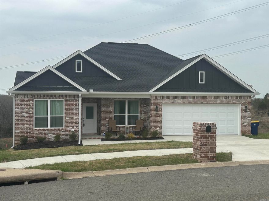 Home built by G2 Contractors.  Many upgrades to include all brick exterior, foam insulation, gutters, and huge yard overlooking the hillside. Three bedrooms and 2 1/2 baths, which is so convenient for guests!  Love the center island with space for six bar stools!  Soft painted trim and cabinetry for soothing relaxation!  Cool electric fireplace that has changing fire colors. Stainless steel appliances and luxury vinyl flooring throughout makes this an easy care home!  The custom tiled walk in shower will be your favorite place in the primary bathroom! Refrigerator, washer & dryer stays! Oversized deck overlooking mother nature! No back yard neighbors!  Builder warranty until Oct 2026. See agent notes.