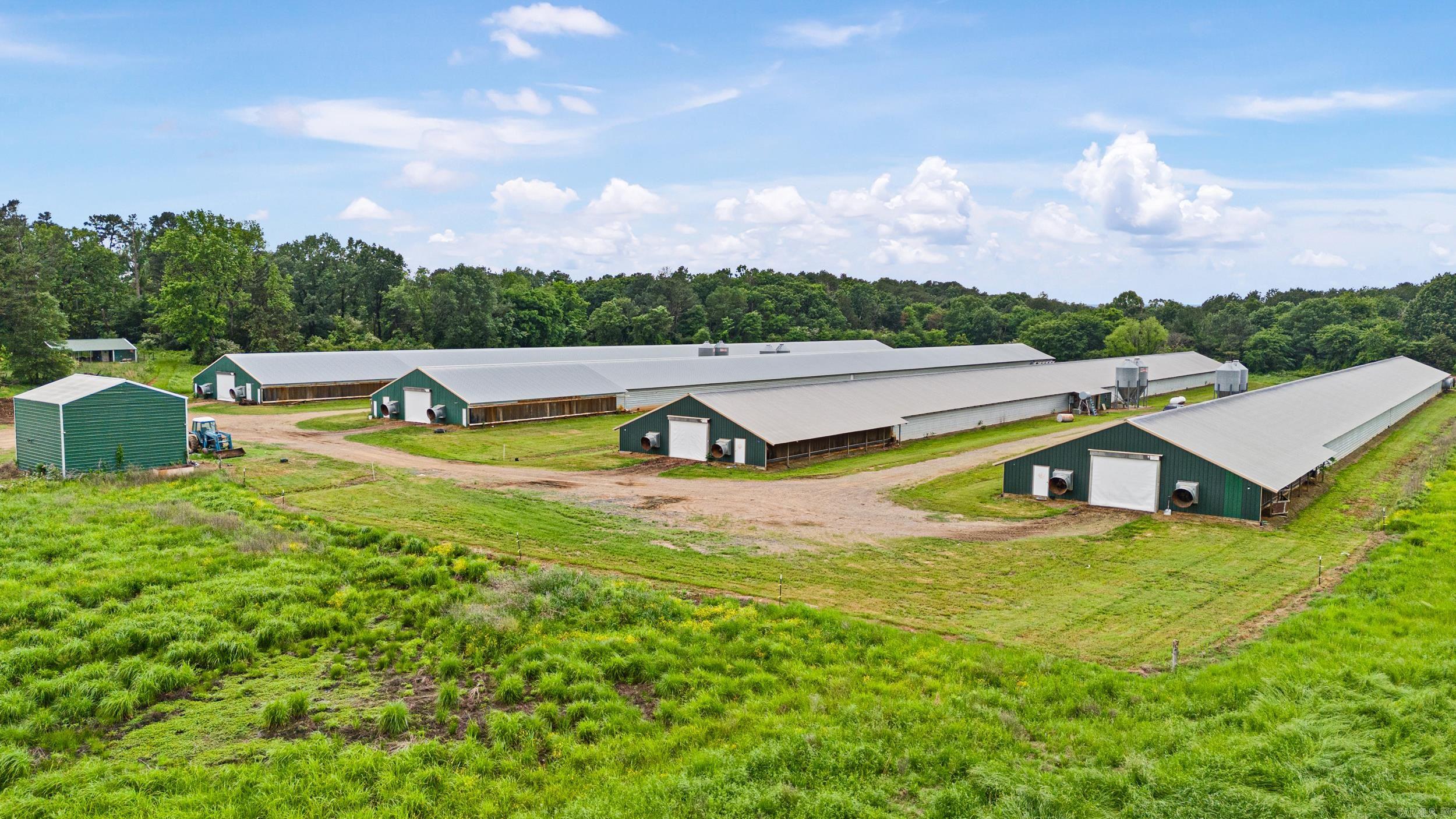 Turn-Key 4-House Wayne Broiler Farm on 70± Acres This fully operational poultry farm offers exceptional income potential and scenic beauty. Featuring (4) 43’x500’ broiler houses with Choretime controls, waterers, and feed lines, this farm is designed for efficiency and ease of operation. Additional improvements include a 40’x105’ litter shed, 30’x20’ water room with (4) 5,100-gallon water tanks, two Deutz generators, and (4) 1,000-gallon propane tanks ensuring seamless production. Stocked pond for fishing. The surrounding lush hay meadows planted in rye and mixed grasses add value and versatility to the property. Enjoy breathtaking views of Mt. Magazine while benefiting from an average annual income of approximately $250,000. An outstanding opportunity to own a proven and profitable farm.