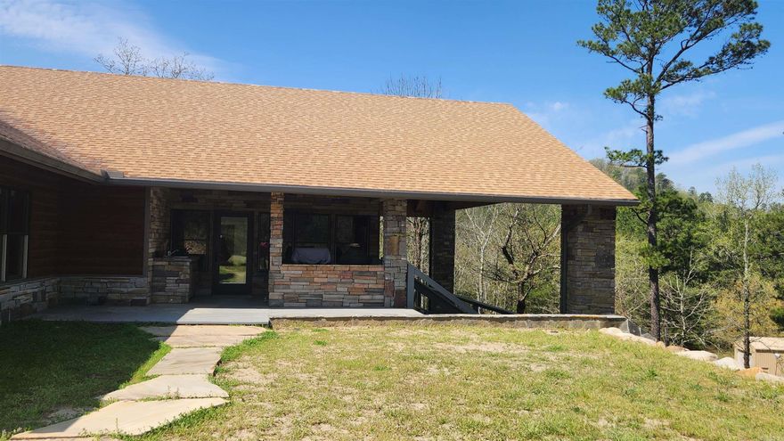 Custom built home sitting on 12.61 acres with an amazing mountain view. Less than a mile to Lake Ouachita. Built in 2015. 2540 sq, 2 bed 2 bath with an office. Attached 2 car carport with concrete. Bathroom floors are heated. Shower in primary suite is a 5' tiled walk-in shower. Primary bath has 2 separate vanities. Home has 3 water heaters to keep everyone supplied with hot water. Vaulted ceilings, granite counter tops, hickory cabinets throughout. Cypress walls in living area. Pella windows in every room. 36" interior doors. Mostly furnished. Stainless Steel KitchenAid appliances. Rock fireplaces (gas logs) in living area and sunroom. Large Sunroom has an amazing view, heated floors and vaulted ceiling. Lots of out door space with wrap around wooden deck (one part is 70x10 and other part is 40x10). Outdoor kitchen has a built-in Big Green Egg, gas grill, sink with cold/hot water. Storm shelter under home. Guest house is fully furnished (672 sq ft) has 2 bedrooms and 1 bath with kitchen. 19x15 "tool shed" with 12 ft porch, 40x16 "boat shed", 32x21 "man cave", 42x20 "barn", well, septic, 24kw Generac generator, 3 acre pine thicket, and stocked pond. The rock work is phenomenal.