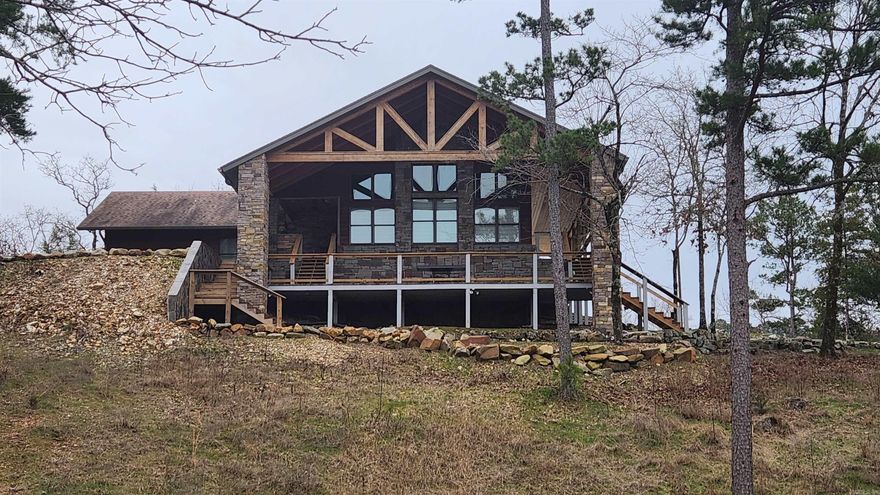 Less than a mile to Lake Ouachita is 12.6 acres. Property features a "main house" (built in 2015) with 2540 sq ft living space. Vaulted ceilings, Pella windows, 16x22 sunroom, office, 2 bed 2 bath with heated floors, 2 sided fireplace, safe room. Outdoor kitchen includes Big Green Egg. "Guest House" 32x21, 2 bedroom 1 bath, kitchen appliances convey (including dishwasher). 19x15 tool shed, 40x16 insulated metal boat/storage shed, "Man Cave" 32x21, "Barn" 42x20. There is also a stocked pond. This property is somewhat secluded and easy to maintain. The exterior rock work adds a natural concept to this unique property, concrete driveway, and 24KW Generac  generator. No restrictions. Fairly private.