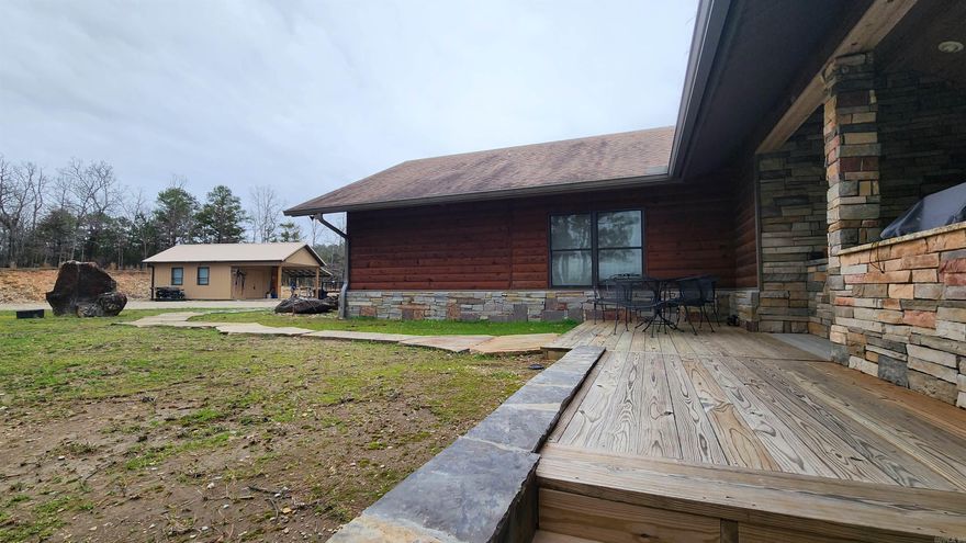 Custom built home sitting on 12.61 acres with an amazing mountain view. Less than a mile to Lake Ouachita. Built in 2015. 2540 sq, 2 bed 2 bath with an office. Attached 2 car carport with concrete. Bathroom floors are heated. Shower in primary suite is a 5' tiled walk-in shower. Primary bath has 2 separate vanities. Home has 3 water heaters to keep everyone supplied with hot water. Vaulted ceilings, granite counter tops, hickory cabinets throughout. Cypress walls in living area. Pella windows in every room. 36" interior doors. Mostly furnished. Stainless Steel KitchenAid appliances. Rock fireplaces (gas logs) in living area and sunroom. Large Sunroom has an amazing view, heated floors and vaulted ceiling. Lots of out door space with wrap around wooden deck (one part is 70x10 and other part is 40x10). Outdoor kitchen has a built-in Big Green Egg, gas grill, sink with cold/hot water. Storm shelter under home. Guest house is fully furnished (672 sq ft) has 2 bedrooms and 1 bath with kitchen. 19x15 "tool shed" with 12 ft porch, 40x16 "boat shed", 32x21 "man cave", 42x20 "barn", well, septic, 24kw Generac generator, 3 acre pine thicket, and stocked pond. The rock work is phenomenal.