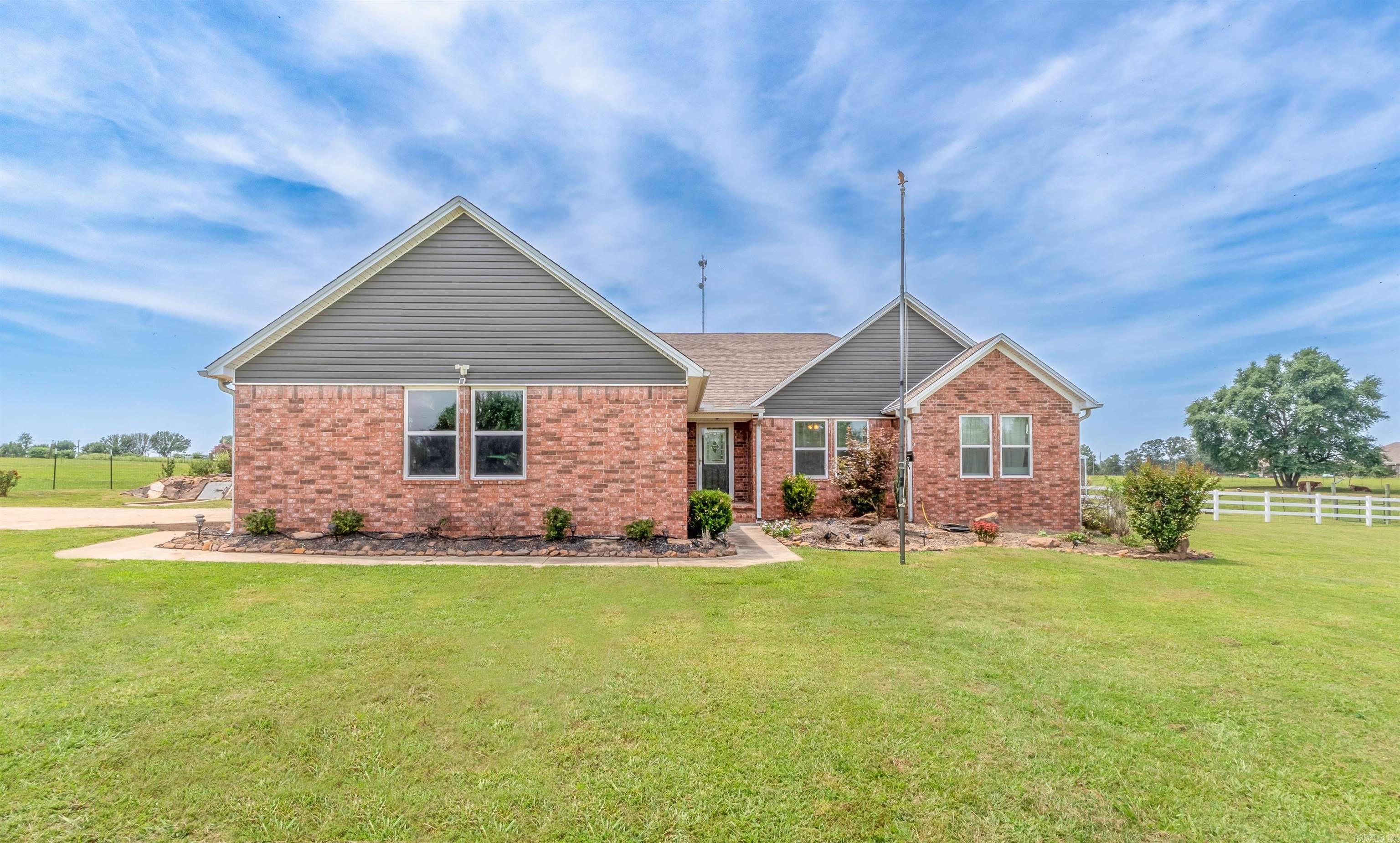 Country Living at it's best! Live in the country with easy access to town, all while enjoying your own quiet space! Gated Entry with code entrance for even more privacy! This nice open concept home has a 12 x 12 screened in back porch off of the living area, a storm shelter and a bonus 32 x 12 tiny home including an 8 x 12 side addition! All of this on 3 acres providing plenty of land to plant a garden and have livestock! There is an 8 x 16 metal storage building and a chicken coupe to convey! Home has updated kitchen backsplash and countertops with an island bar. Spacious living room has a gas fireplace. Hall bathroom has been updated! Large master bedroom suite with a sitting area and a huge closet. Large master bath with walk in shower and 2 closets. Yes! 3 master closets! Home has some new paint and laminate flooring in living area and hallway. Home has new windows 2021, new heat pump 2023 and a Generac 11 KWatt generator is approximately 3 years old! Backup propane tank on property. Hurry, this Home Sweet Home has it all and will go fast! Solar panels do not convey. (measuring is suggested)