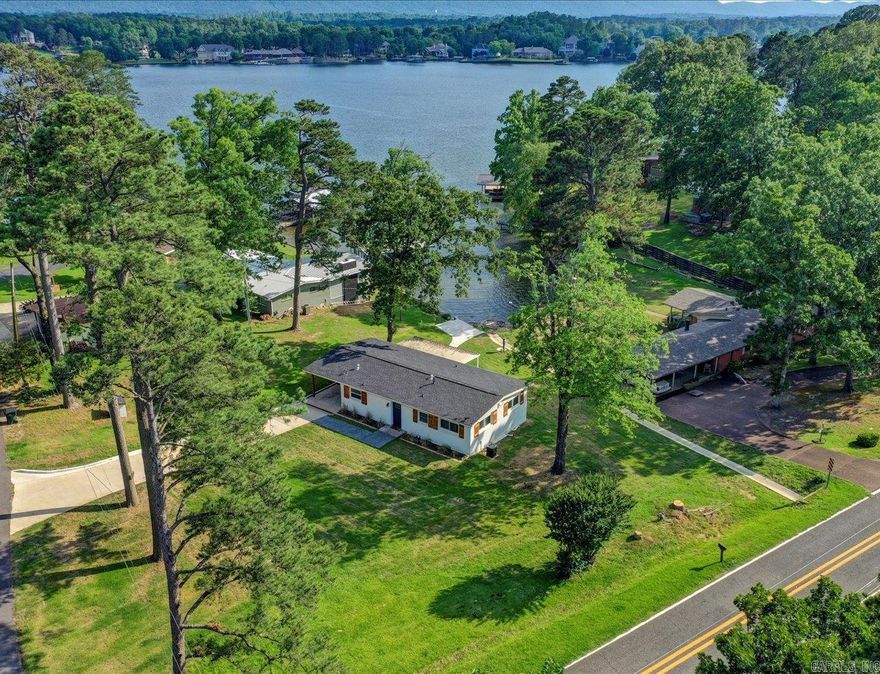 Experience waterfront living on Lake Hamilton at an affordable price. This beautifully remodeled home features granite countertops, stainless steal appliances, double wall ovens, newly refinished hardwood floors, and walk in shower. The heat exchange was replaced in 2016. New windows, roof, sod, sprinkler system,  installed 2023. Interior and exterior were painted in 2023. Located in a quiet cover across the bay from Driftwood Point.