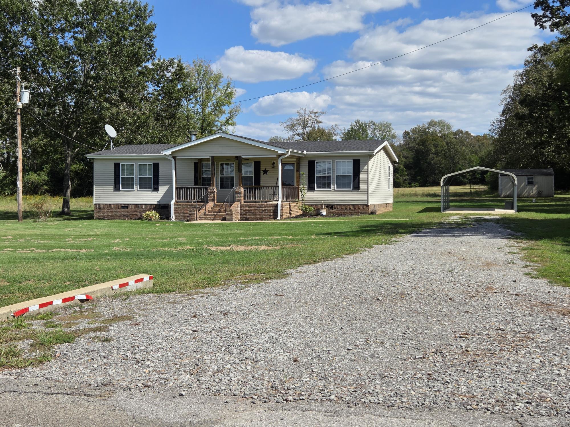 Very nice double wide on permanent foundation with sheetrock walls & ceilings on 2 acres just a few miles northwest of Searcy. Nice level land, 2 car detached carport, storage building, large back deck & covered front porch with swing. Inside you will find a foyer, open floorplan with fireplace in the living room & a kitchen with a long breakfast bar & pantry. The primary bedroom has an attached spacious bathroom with a garden tub, standup shower, double sinks that has an exterior back door. The added sunroom has a Mini split & wrap around windows for relaxing but could be used as a game room, 4th bedroom, office or den. If you do not need the extra acre to the left, sell it or have a relative or friend build on it. See agent remarks.